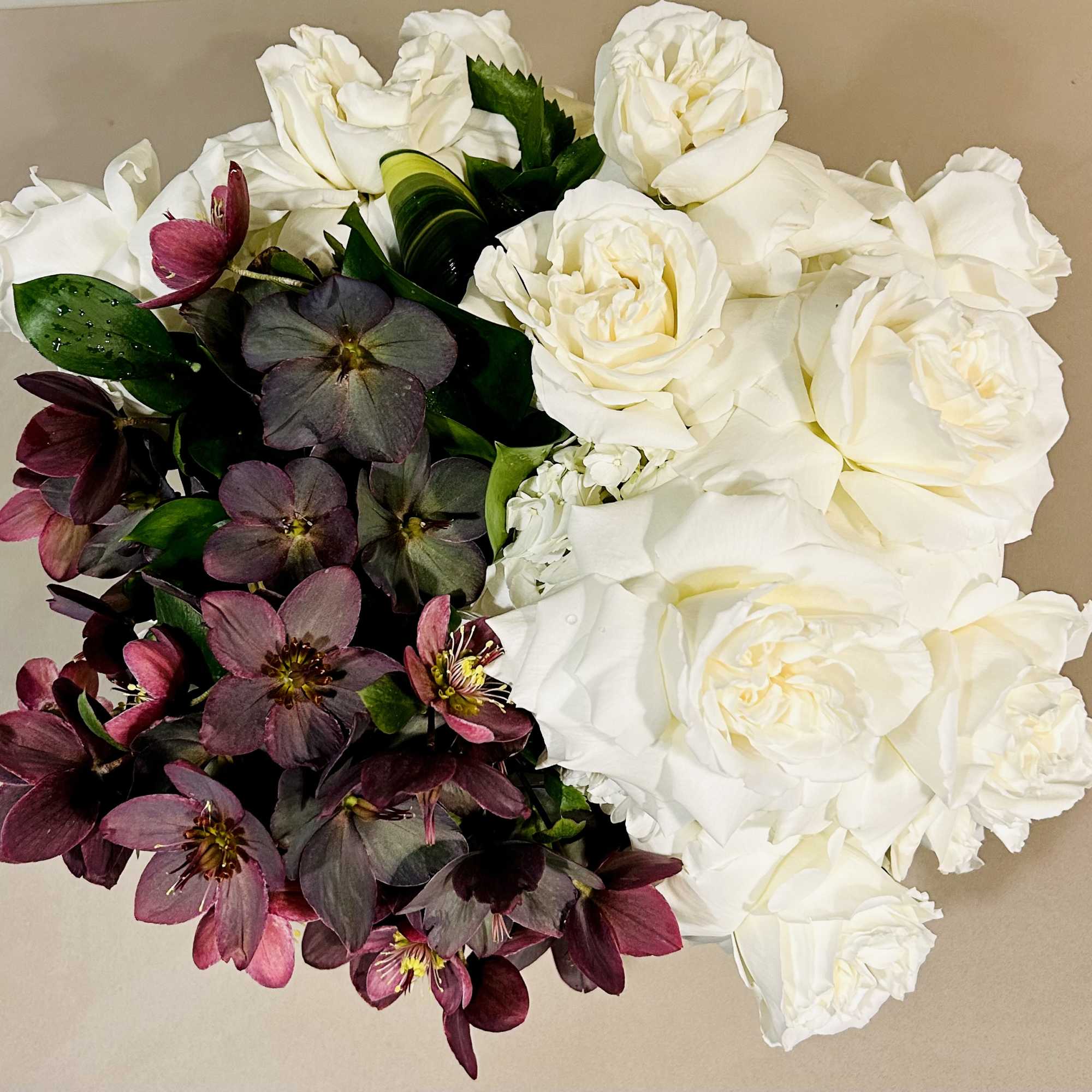 Roses and Hellebores in white glass vase.