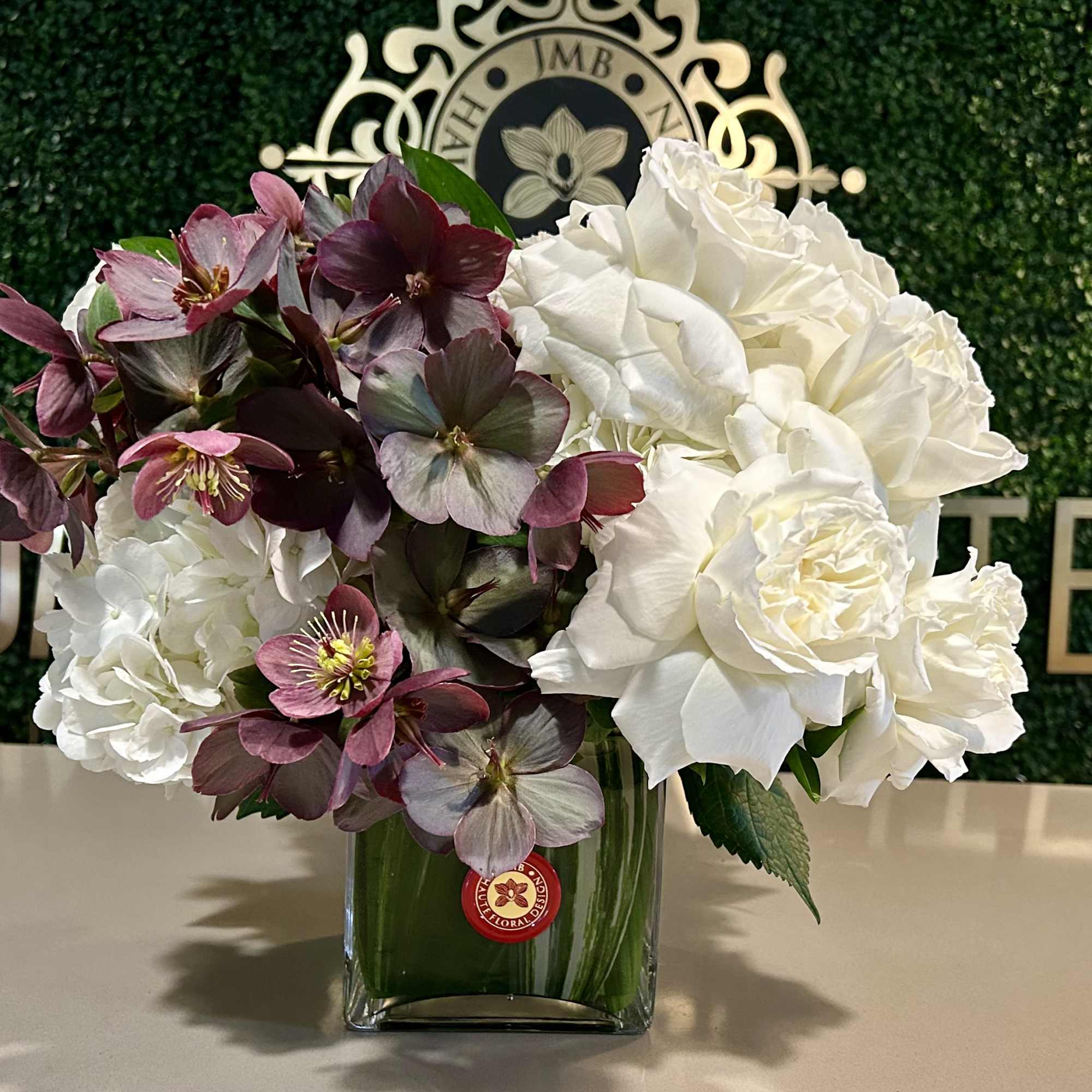 Roses and Hellebores in white glass vase.