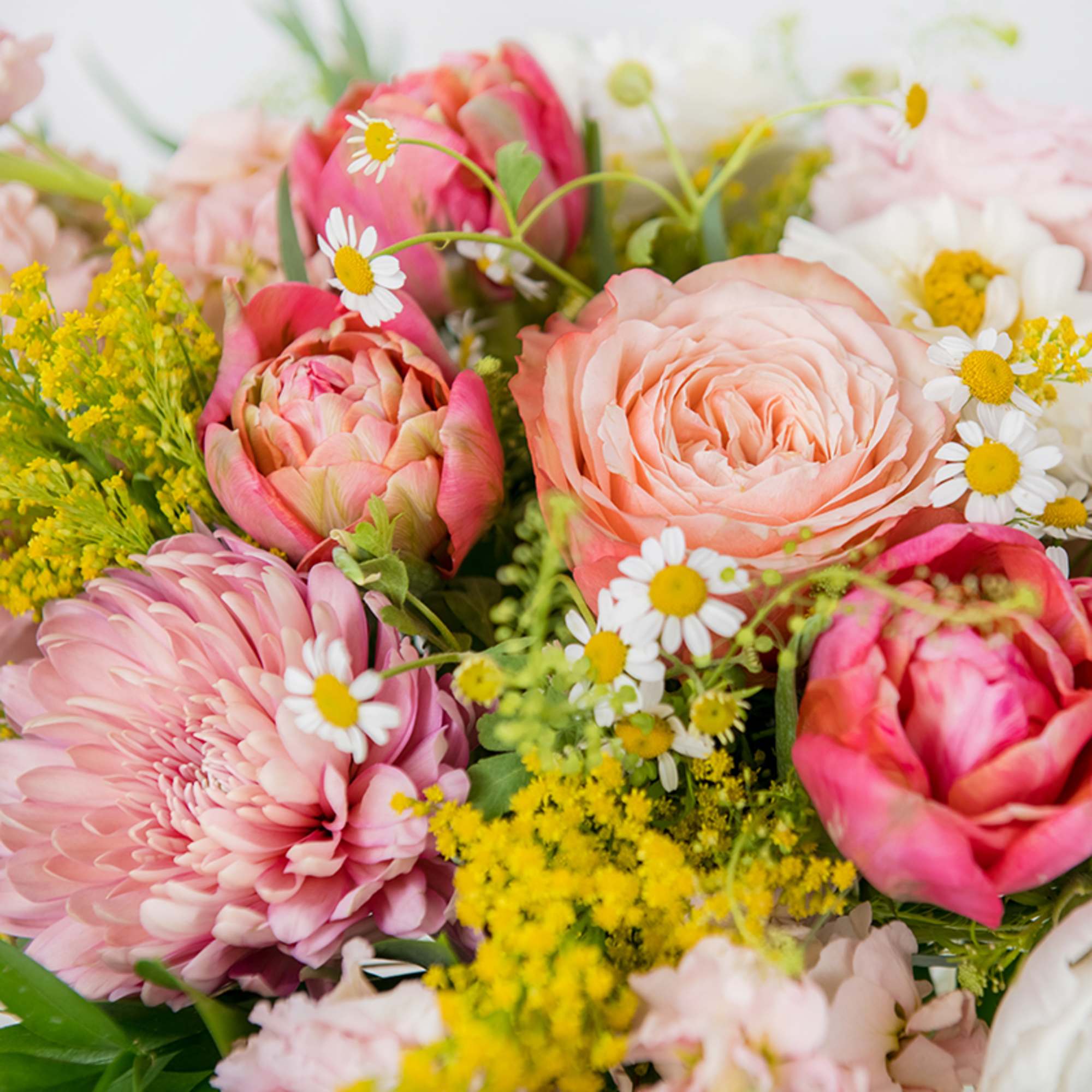 Mixed bouquet of pink and peach flowers with yellow and white accents