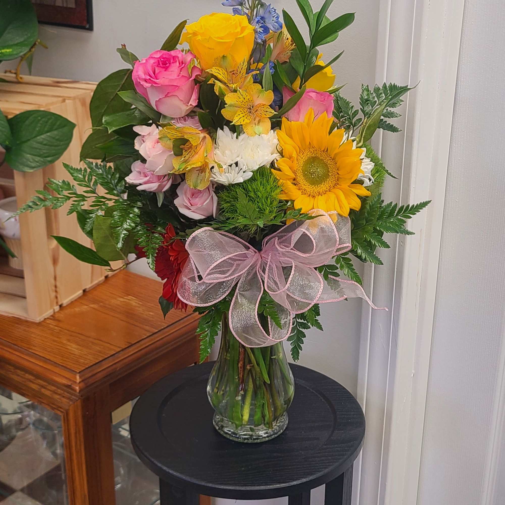 Bright yellow roses and a single bold sunflower anchor this birthday bouquet