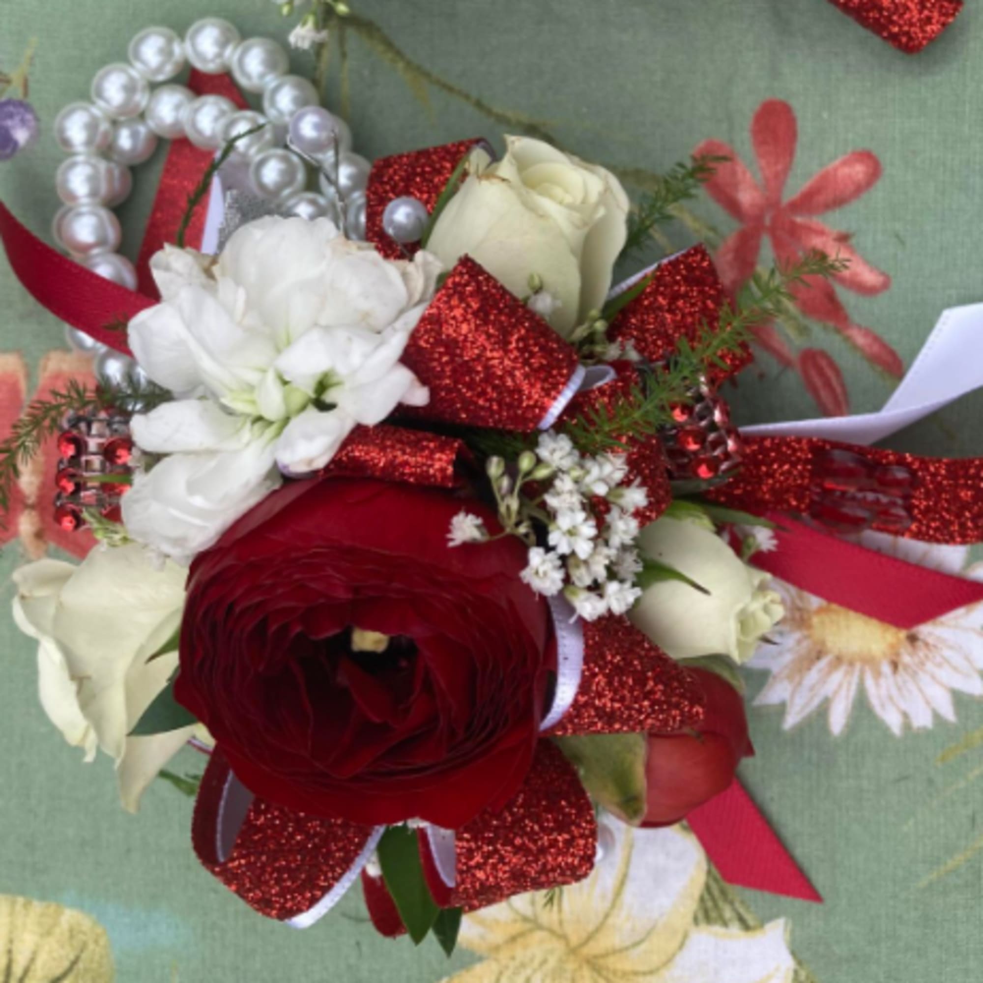 Red and white floral corsage with glitter ribbon and pearl accents