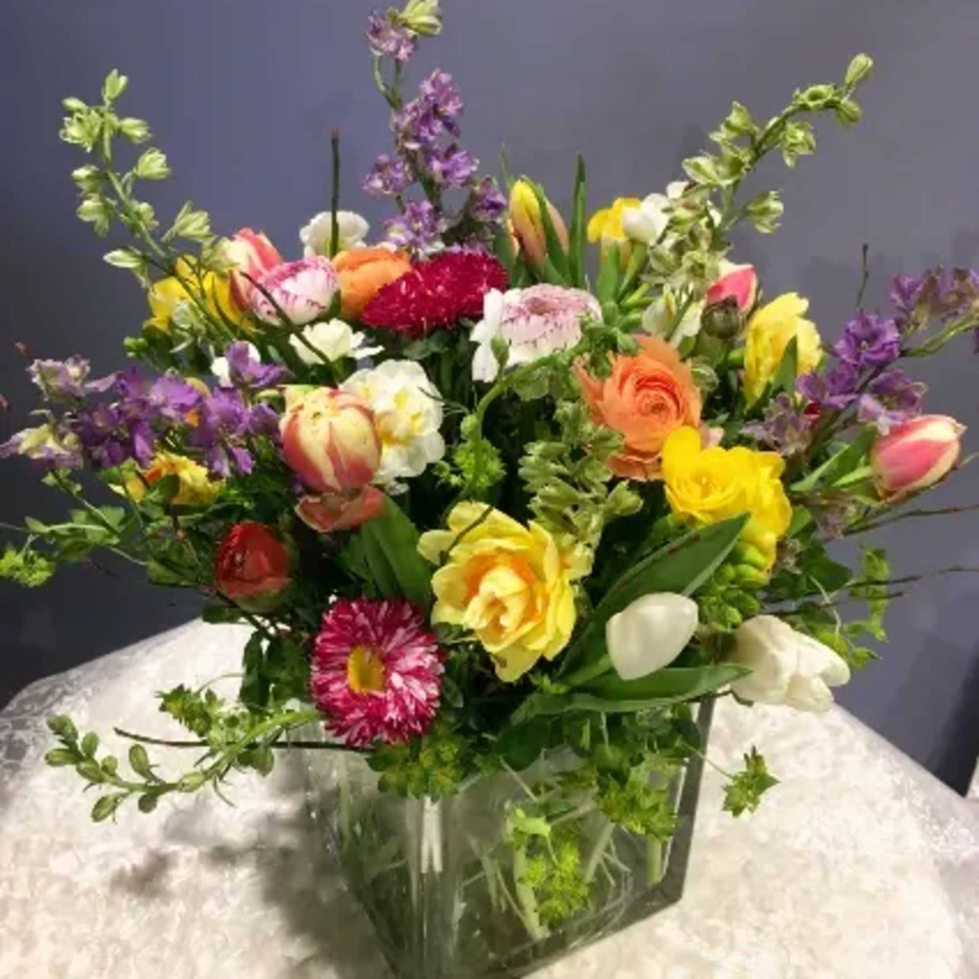 This beautiful arrangement is made with a variety of decadent spring flowers: