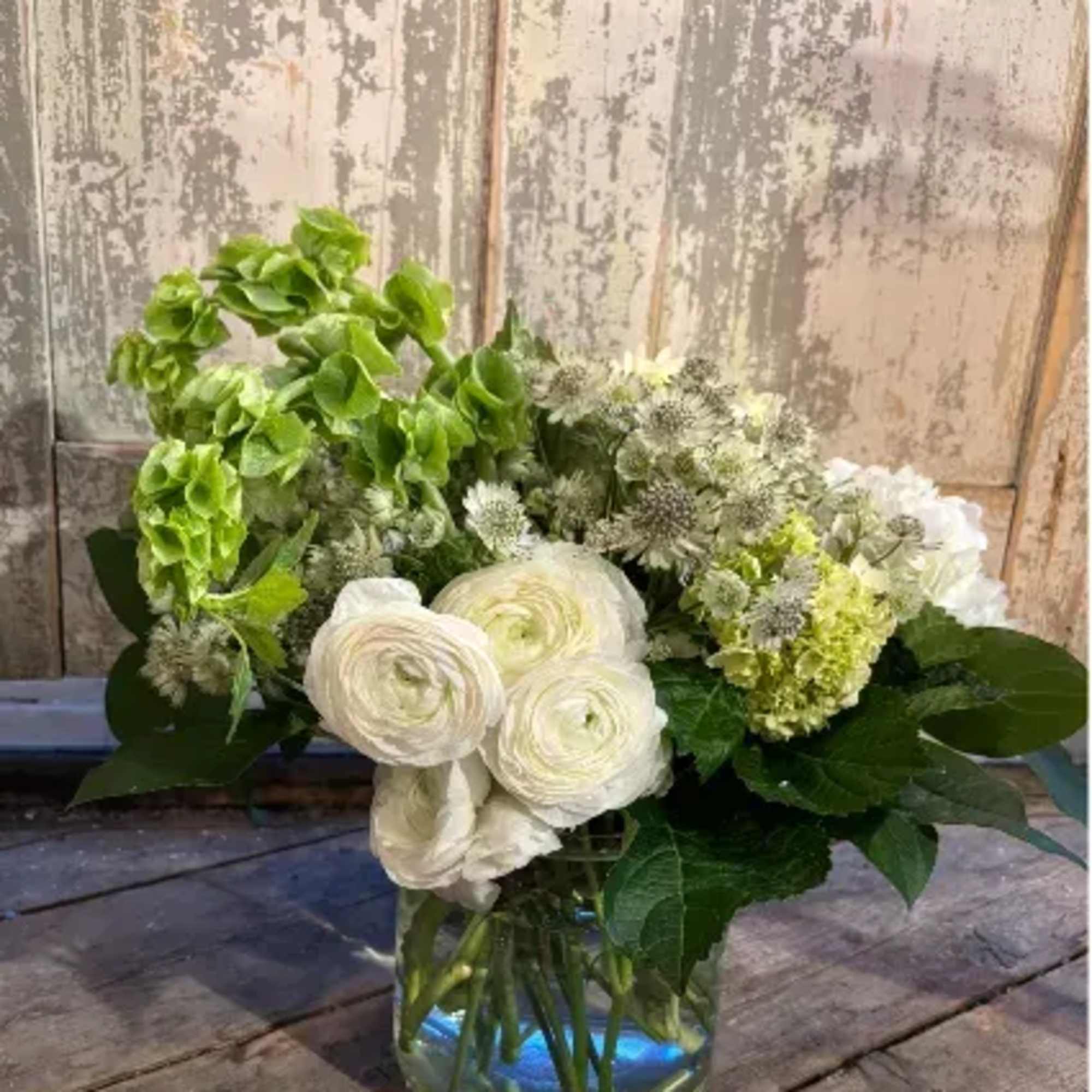 Seasonal green and white arrangement in a glass vase

Includes:
Standard: Bells Of Ireland