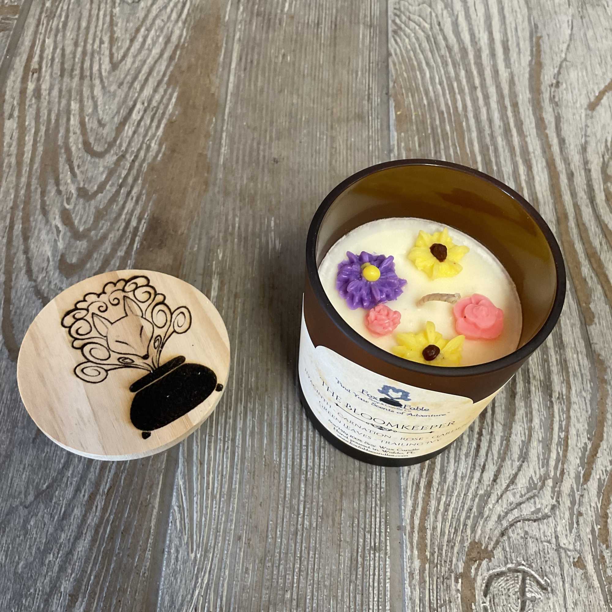 Decorative candle in a brown glass jar with a wooden lid