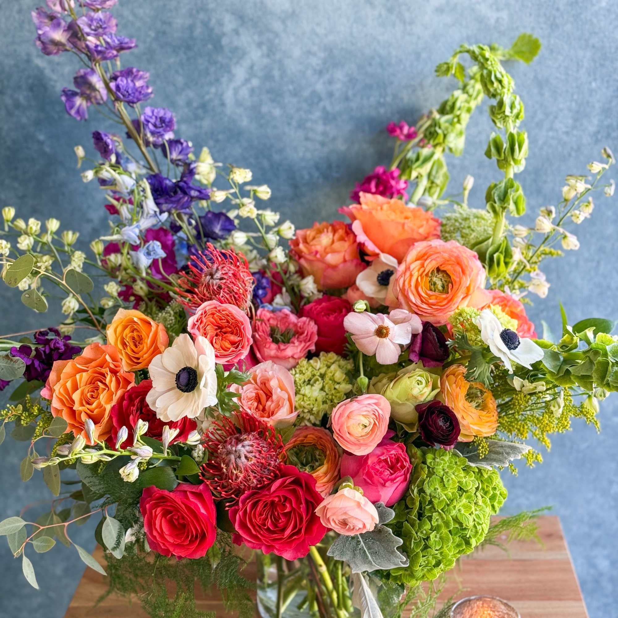 Colorful mixed bouquet in a glass vase with roses and purple blooms
