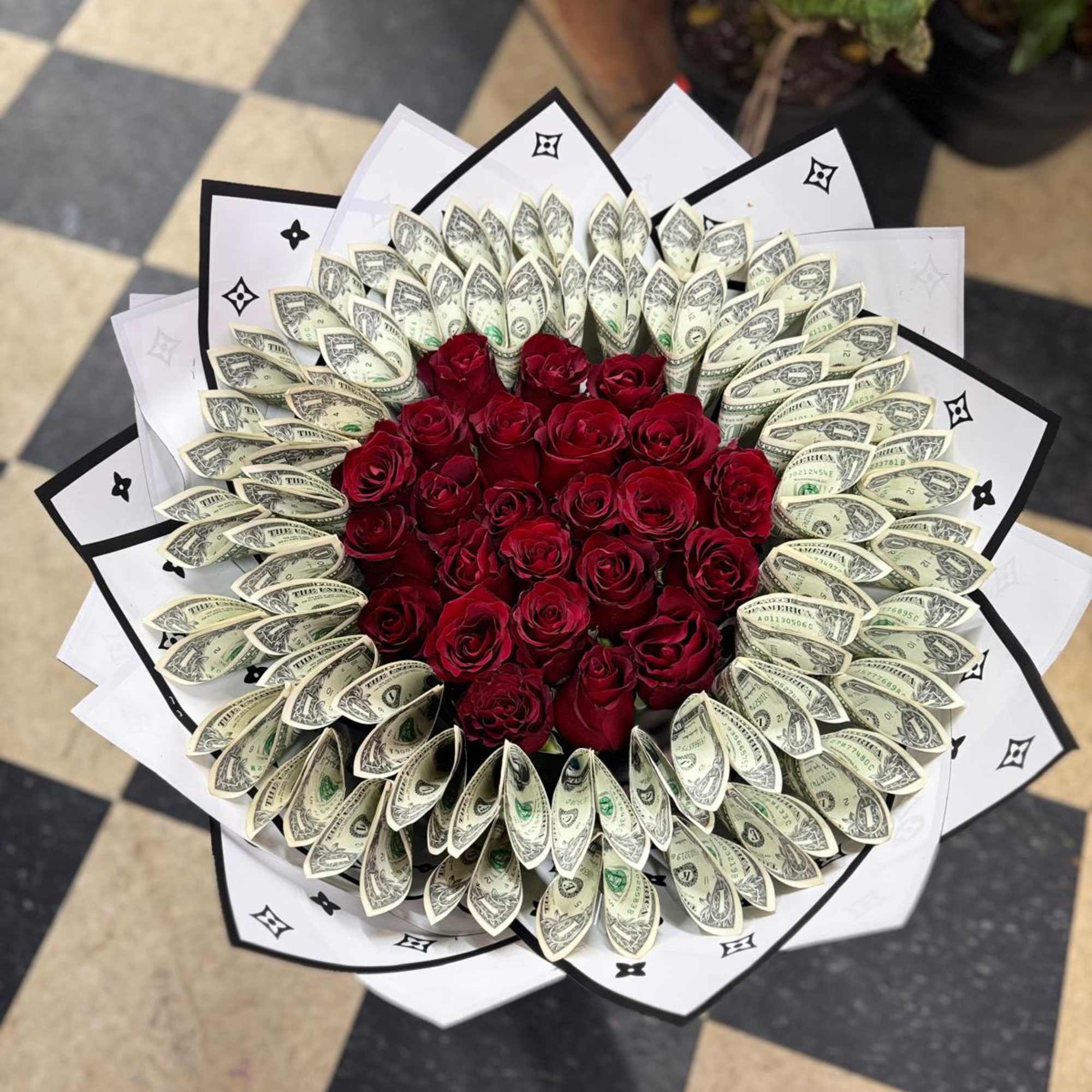 Bouquet of red roses surrounded by folded dollar bills