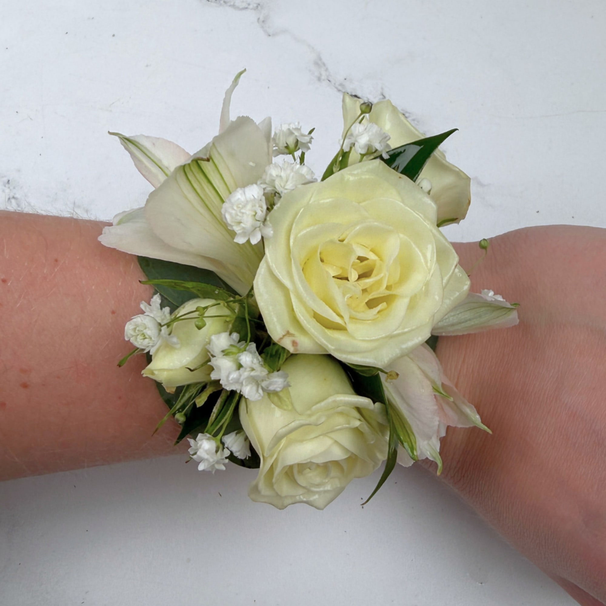 The Elegant Ivory Corsage features four white/ivory spray roses and two alstroemeria