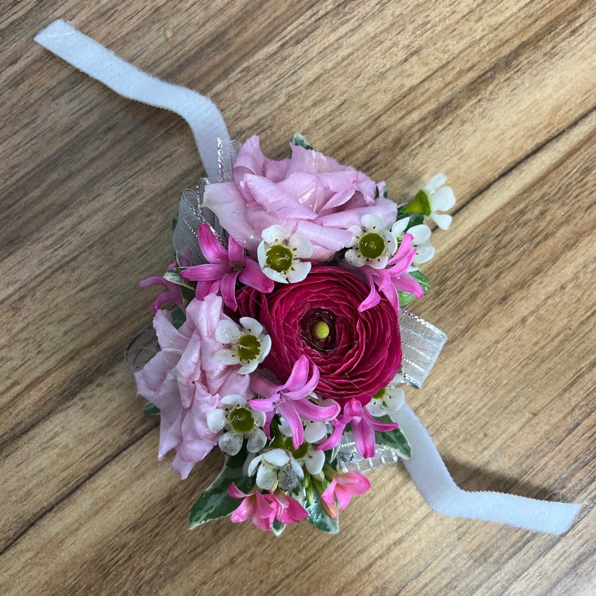 Small pink floral wrist corsage with ribbon ties
