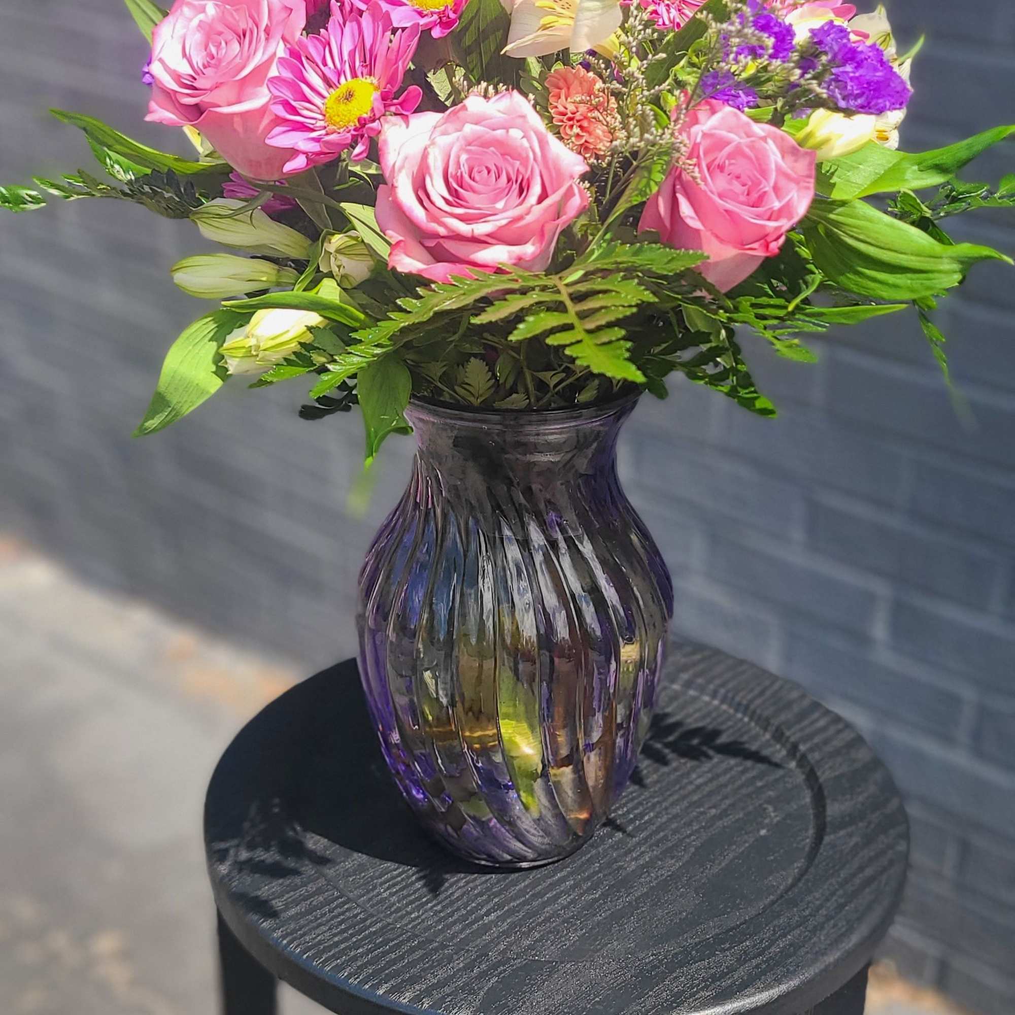 Soft pink roses and vivid magenta daisies mingle with white alstroemeria and