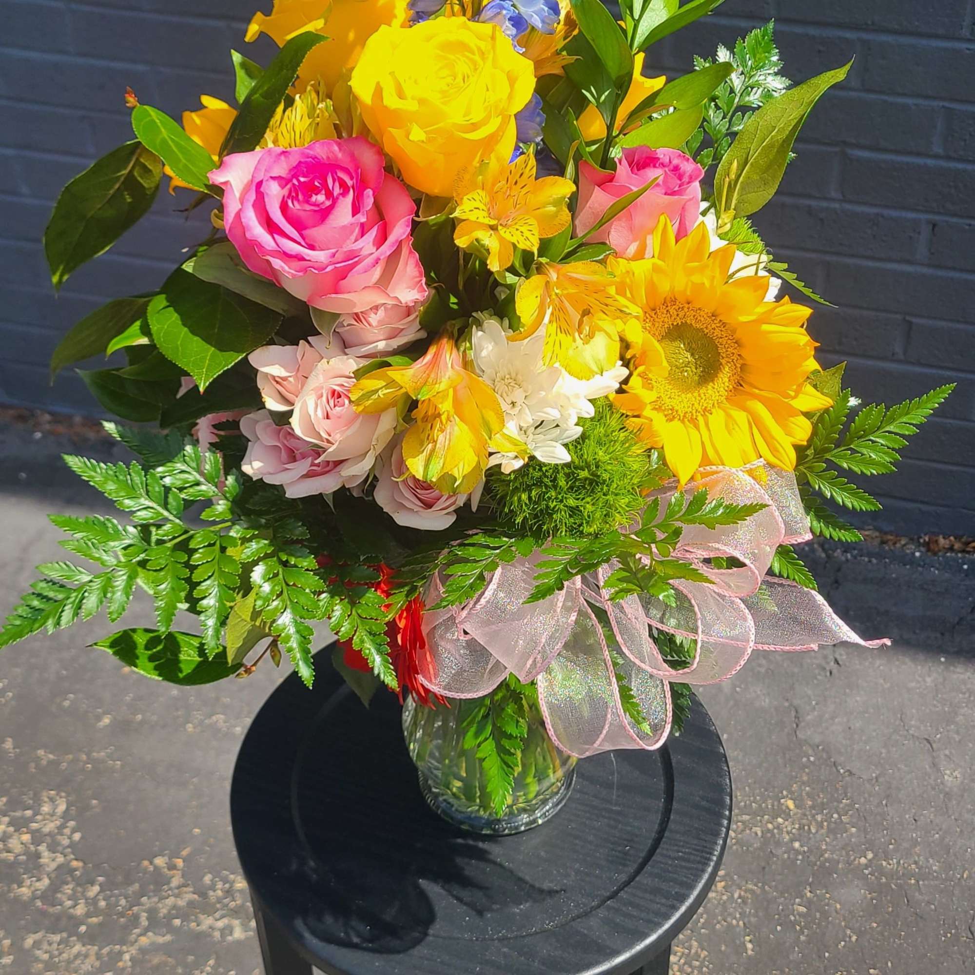 Sunshine and soft pastels meet in this tall flower arrangement-perfect as a