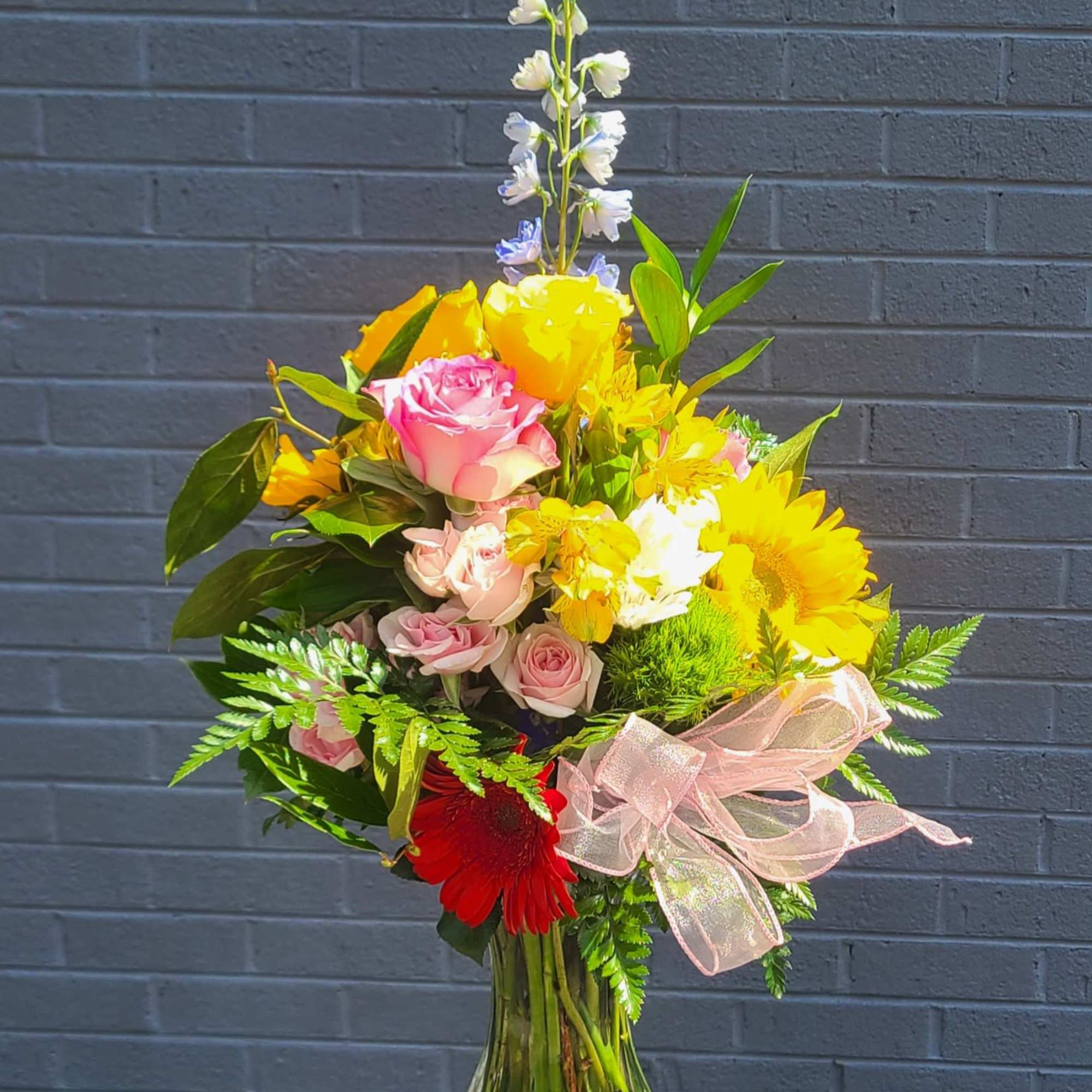 Sunshine and soft pastels meet in this tall flower arrangement-perfect as a