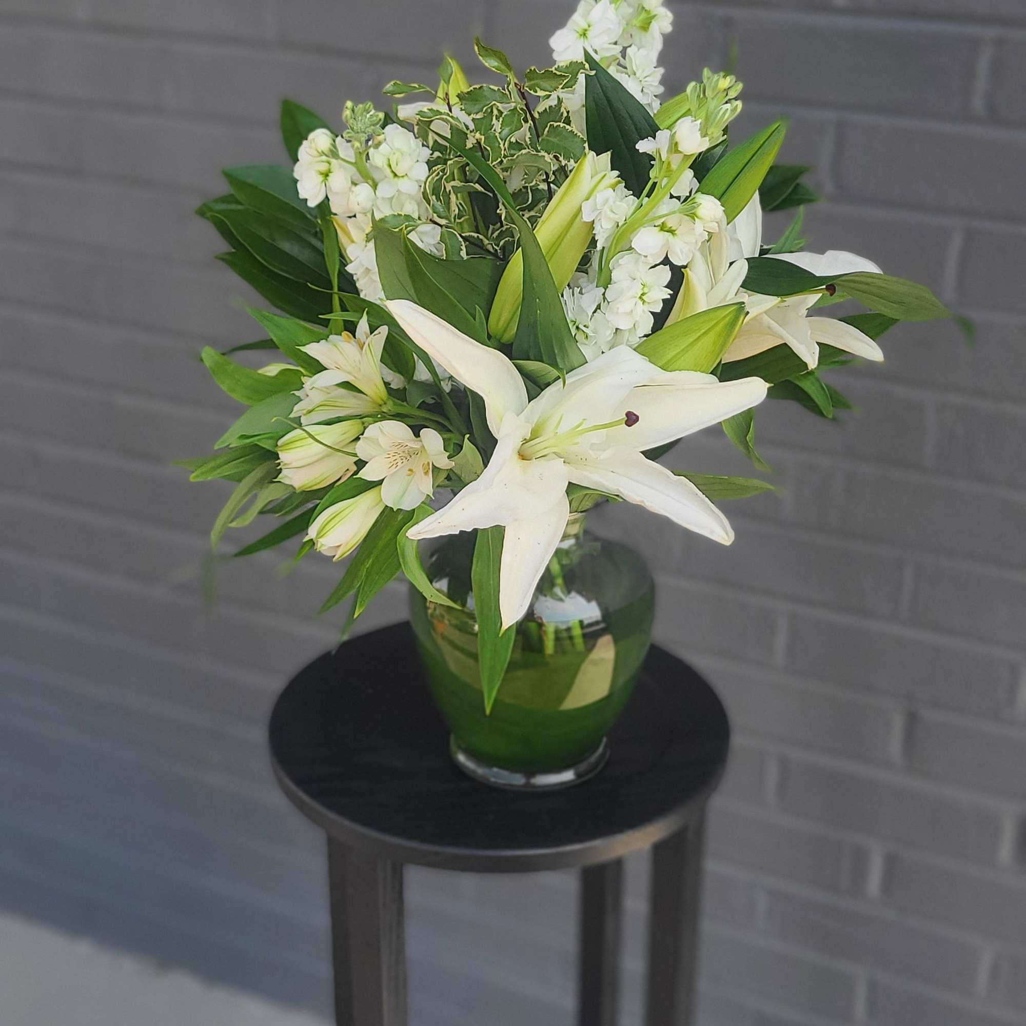 Pure white lilies take center stage in this elegant white-and-green bouquet, a