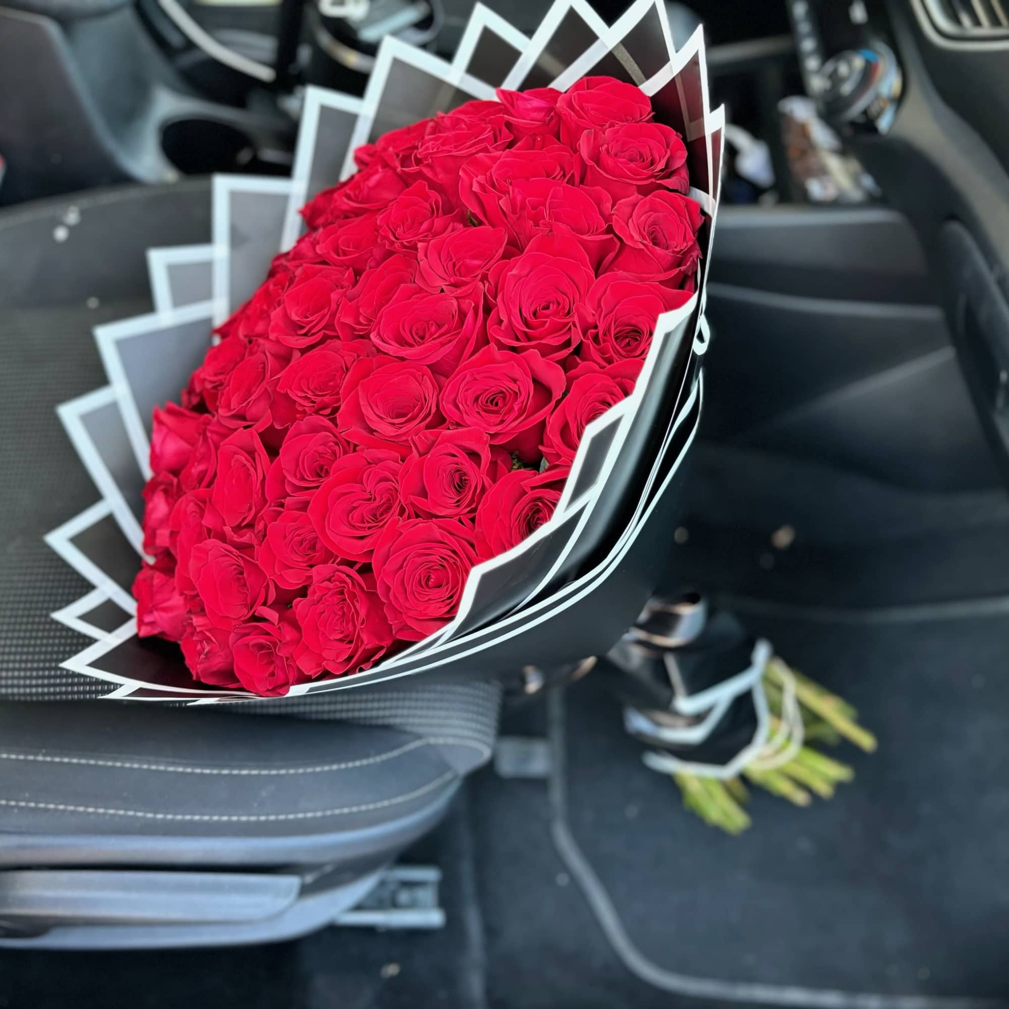 Large bouquet of red roses wrapped in black and white paper