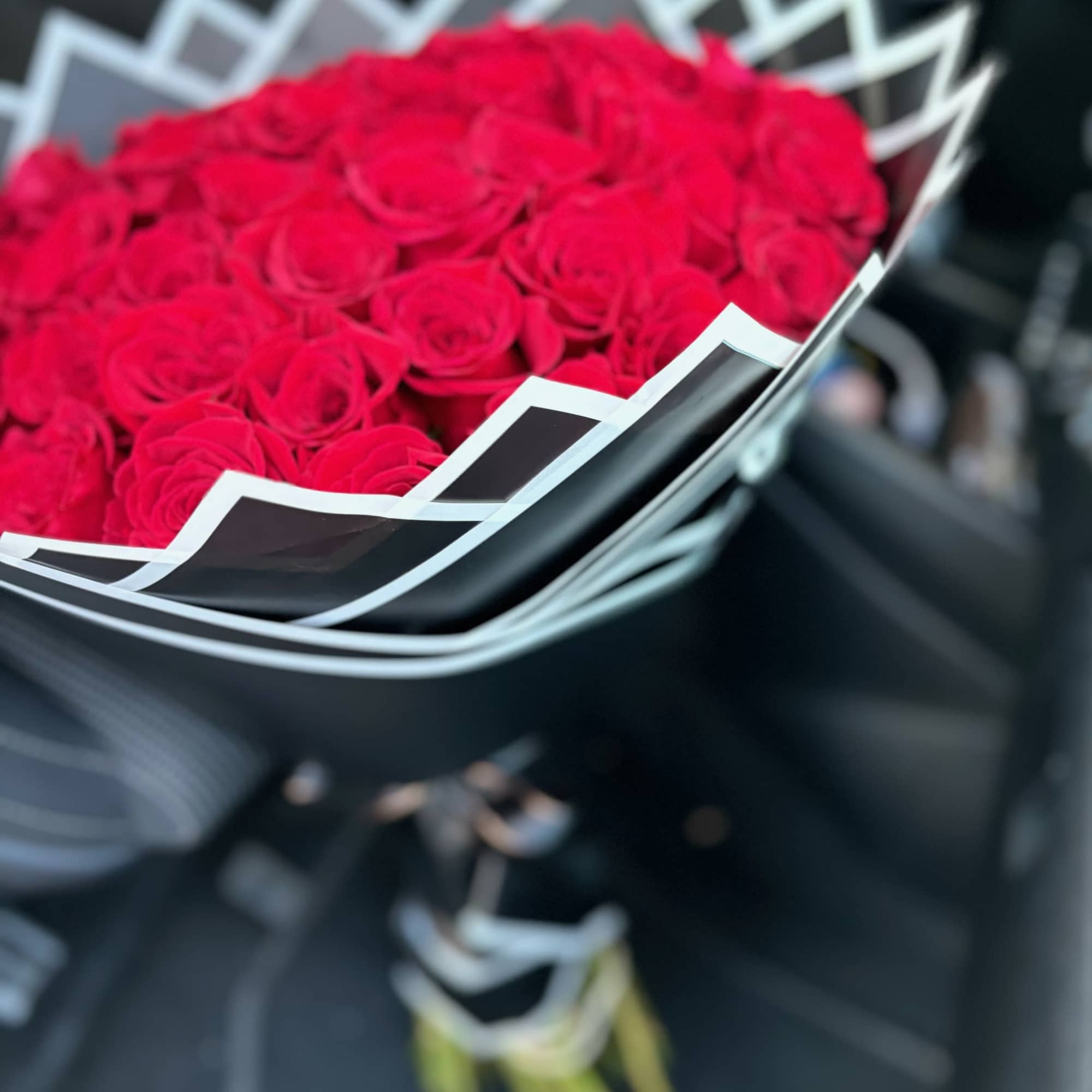 Bouquet of red roses wrapped in black paper