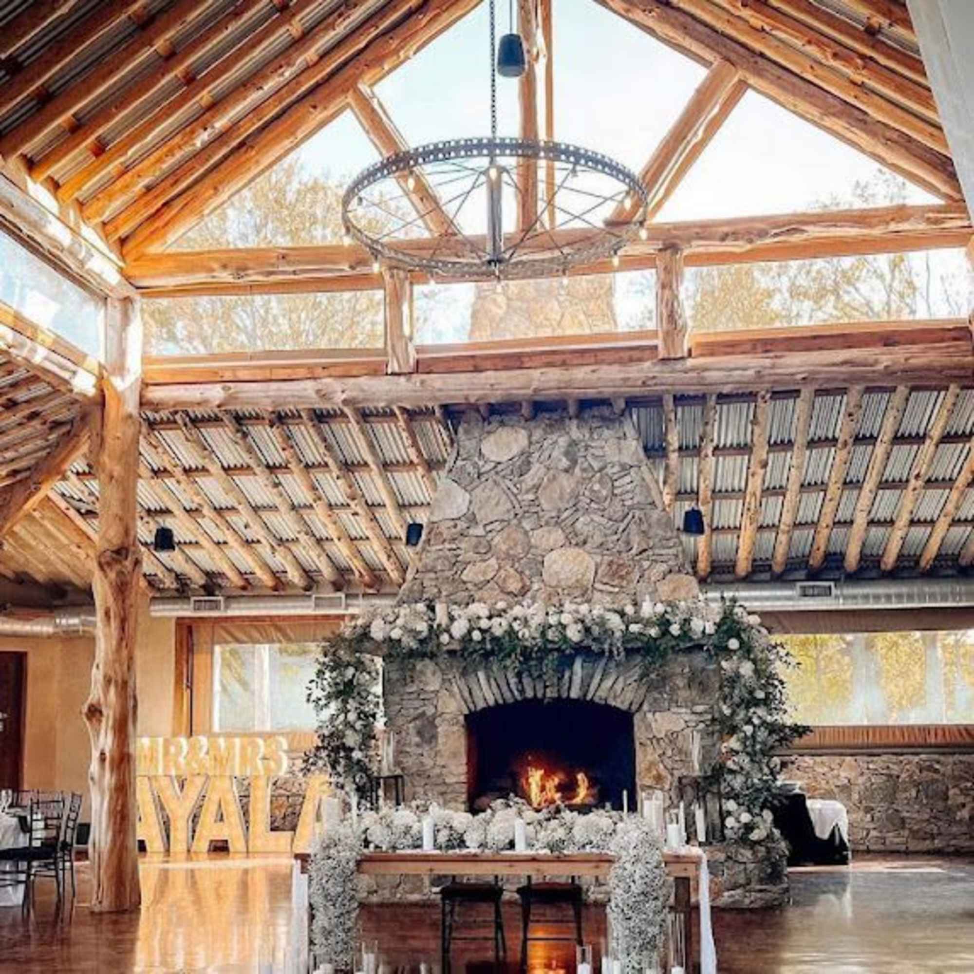 Stone fireplace decorated with white flowers in a rustic hall