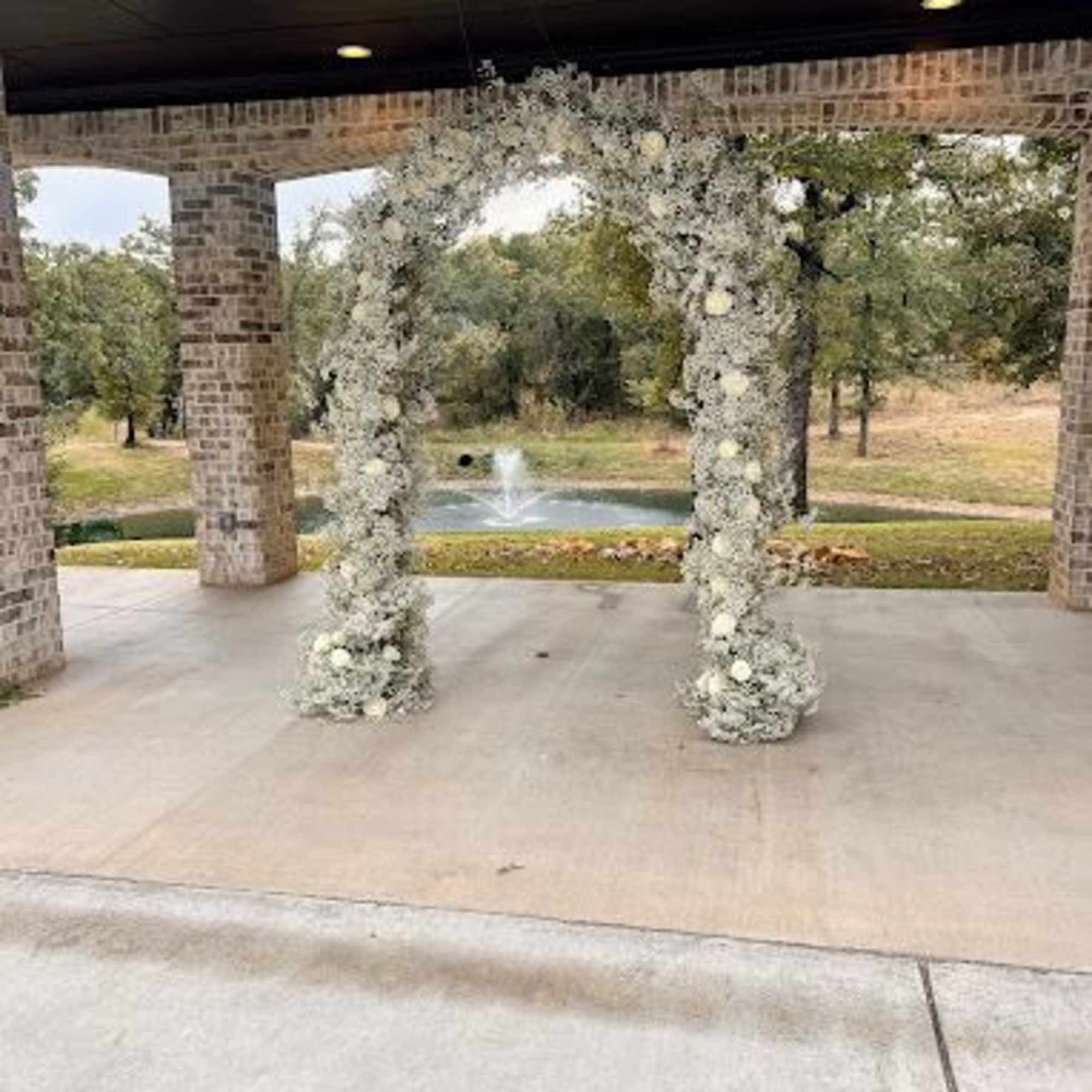 White floral arch at an outdoor pavilion
