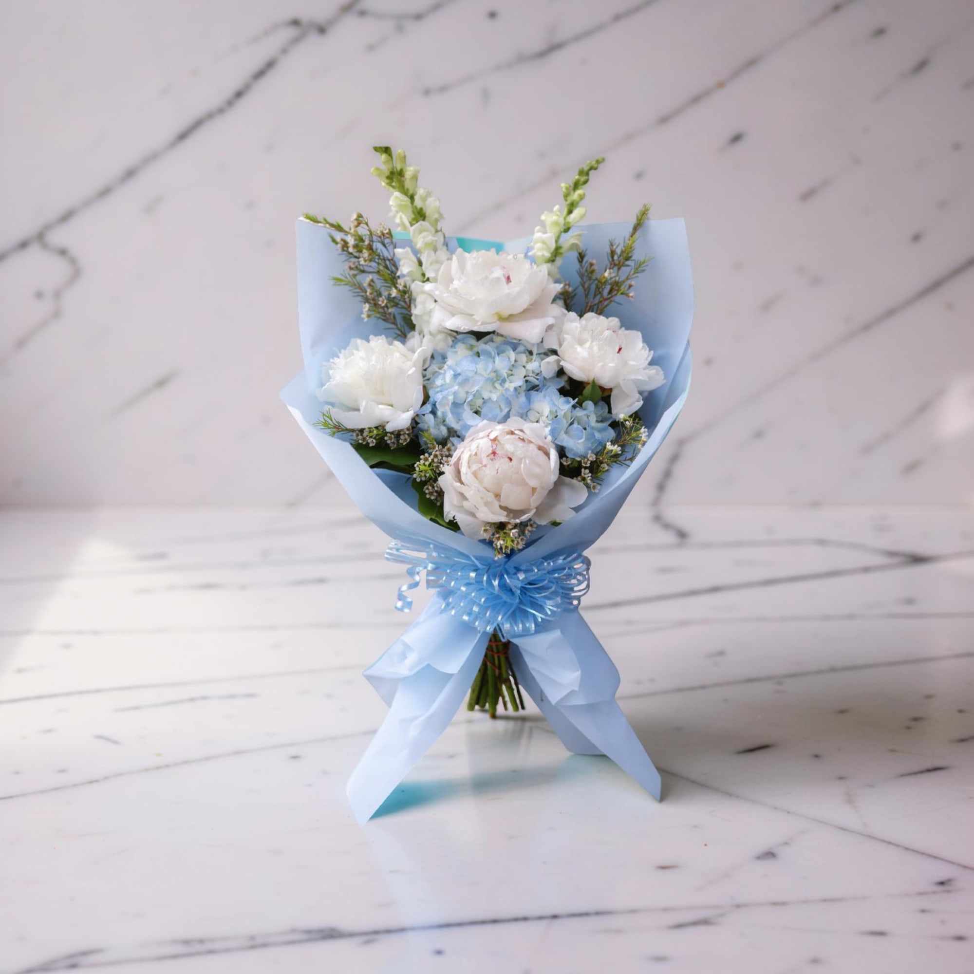 A soft and elegant hand-wrapped bouquet inspired by Columbia University, featuring delicate