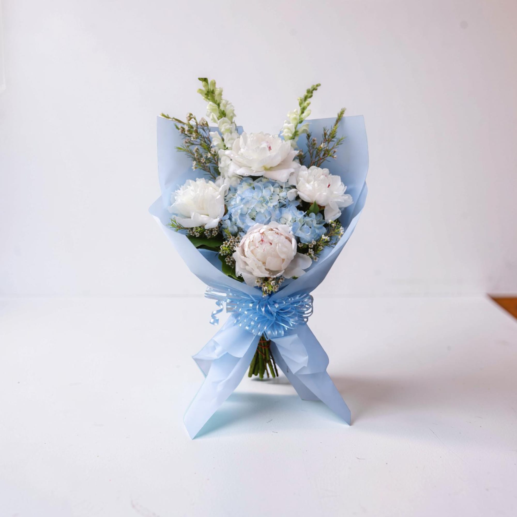A soft and elegant hand-wrapped bouquet inspired by Columbia University, featuring delicate