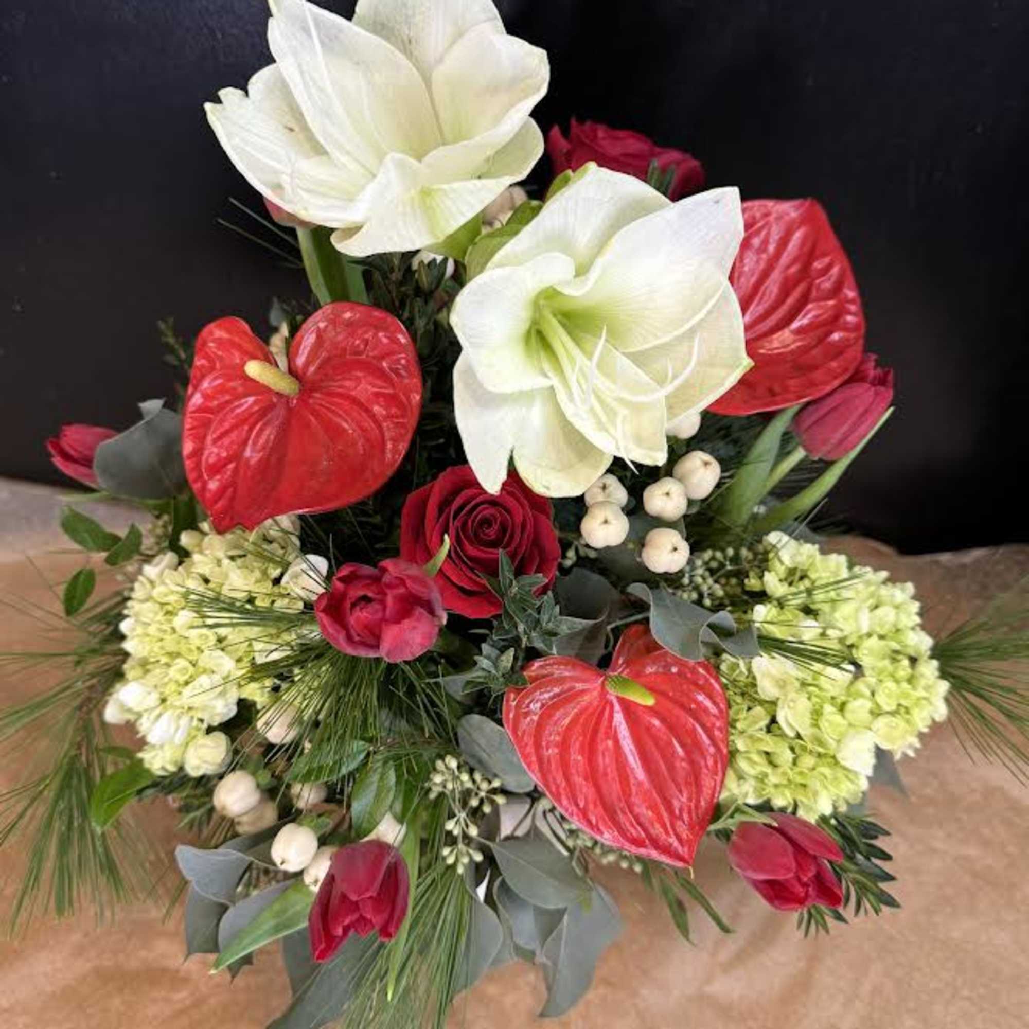 Arrangement of white lilies, red anthuriums, and red tulips