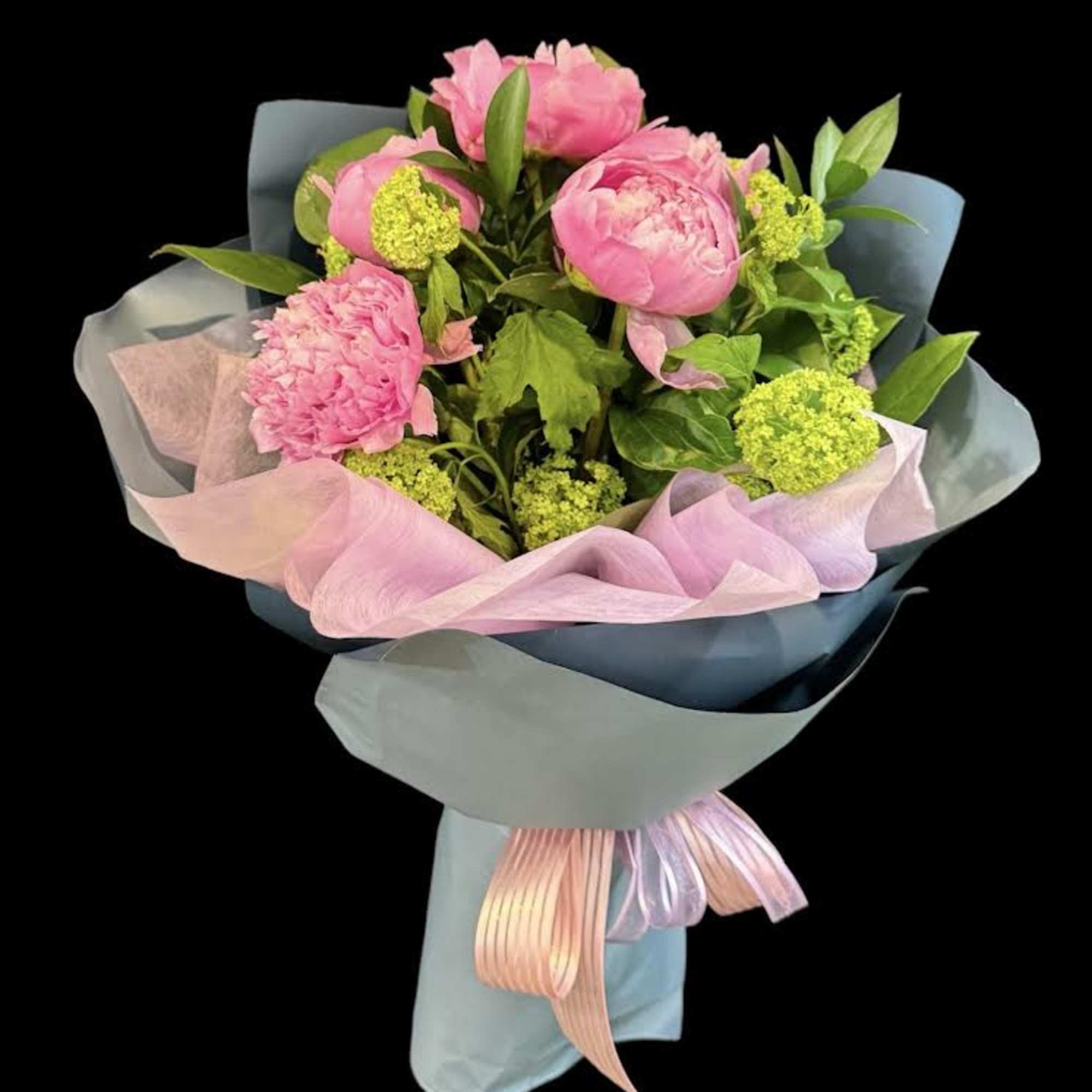 Pink peony bouquet wrapped in pastel paper with ribbon