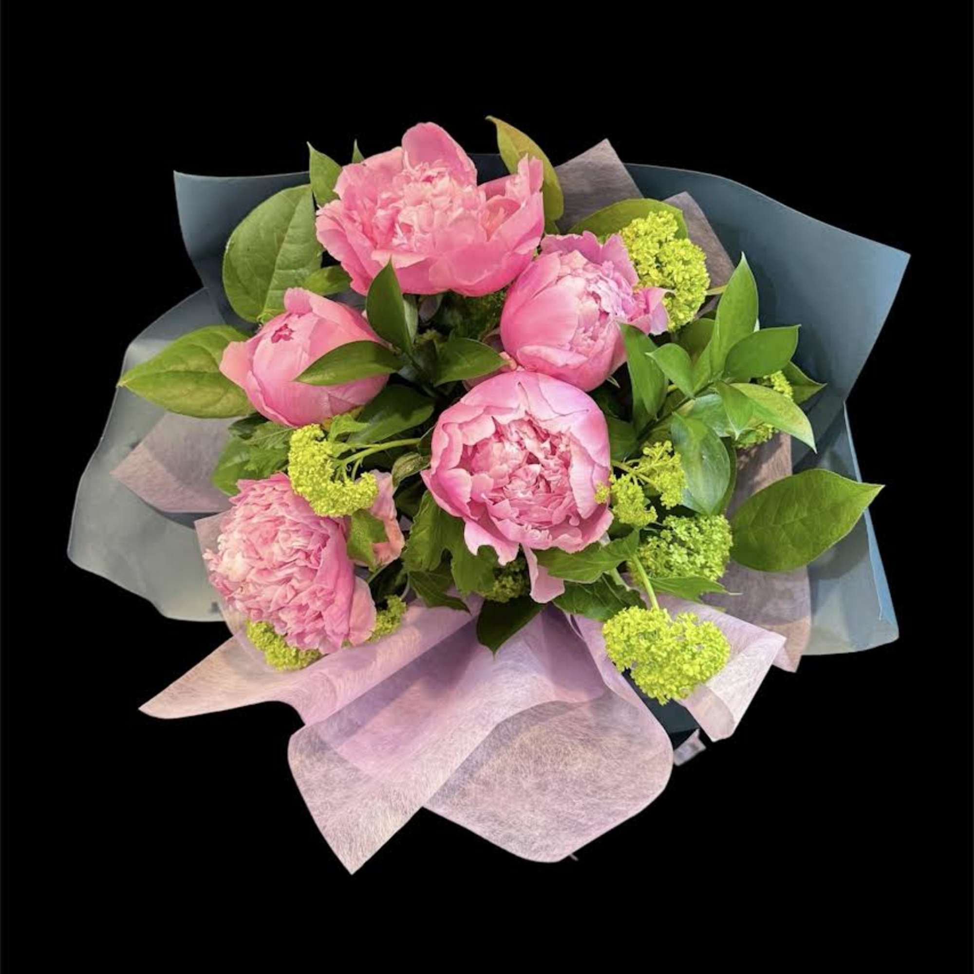 Pink peonies with green accents wrapped in pastel paper