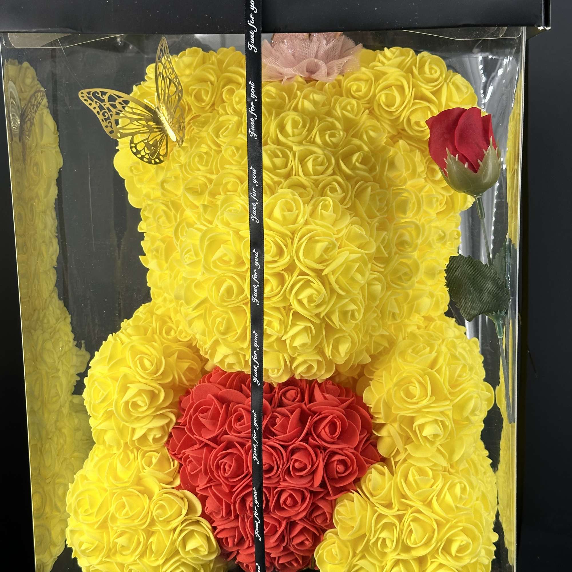 Yellow teddy bear made of roses in a gift box with a red heart