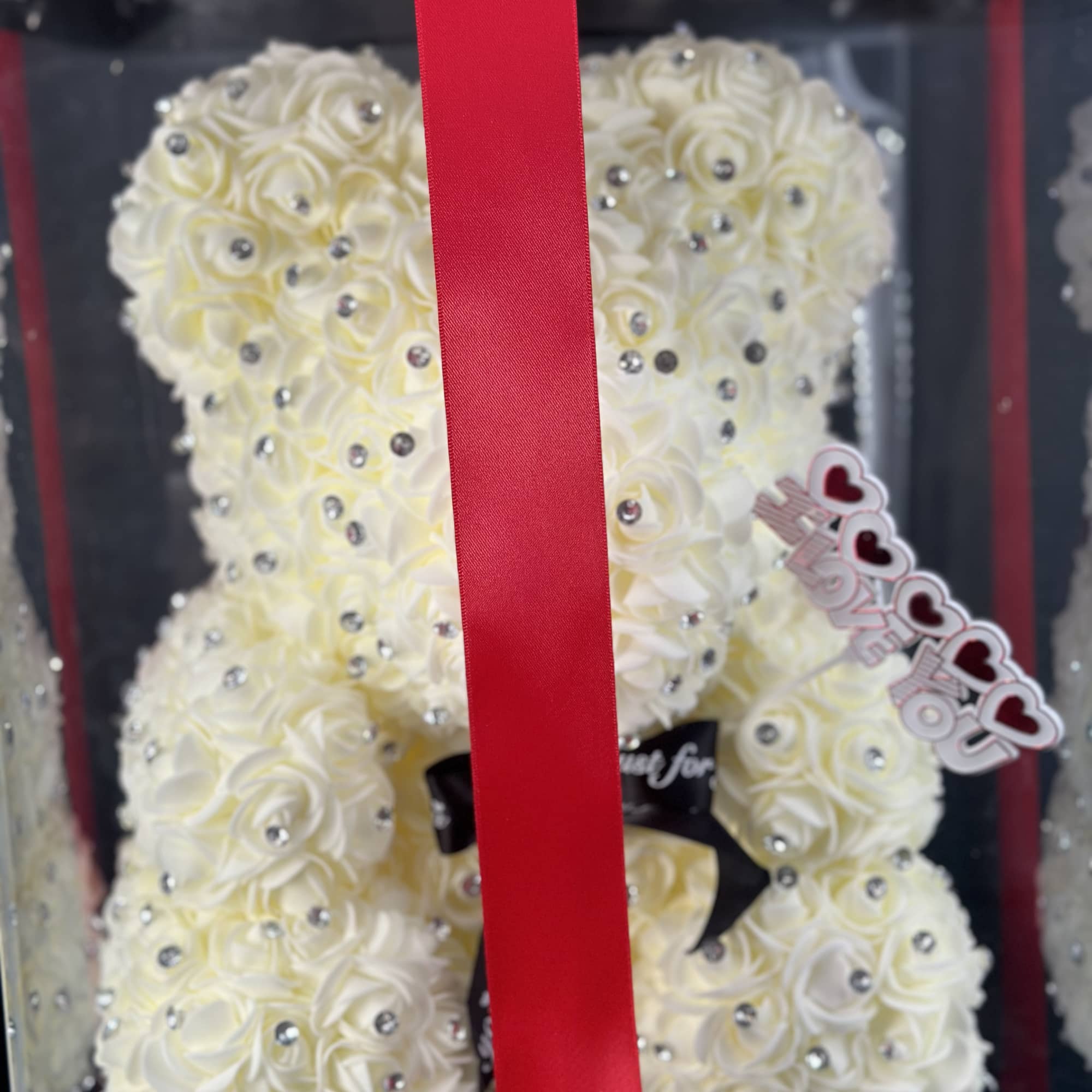 White rose teddy bear in a gift box with a red ribbon