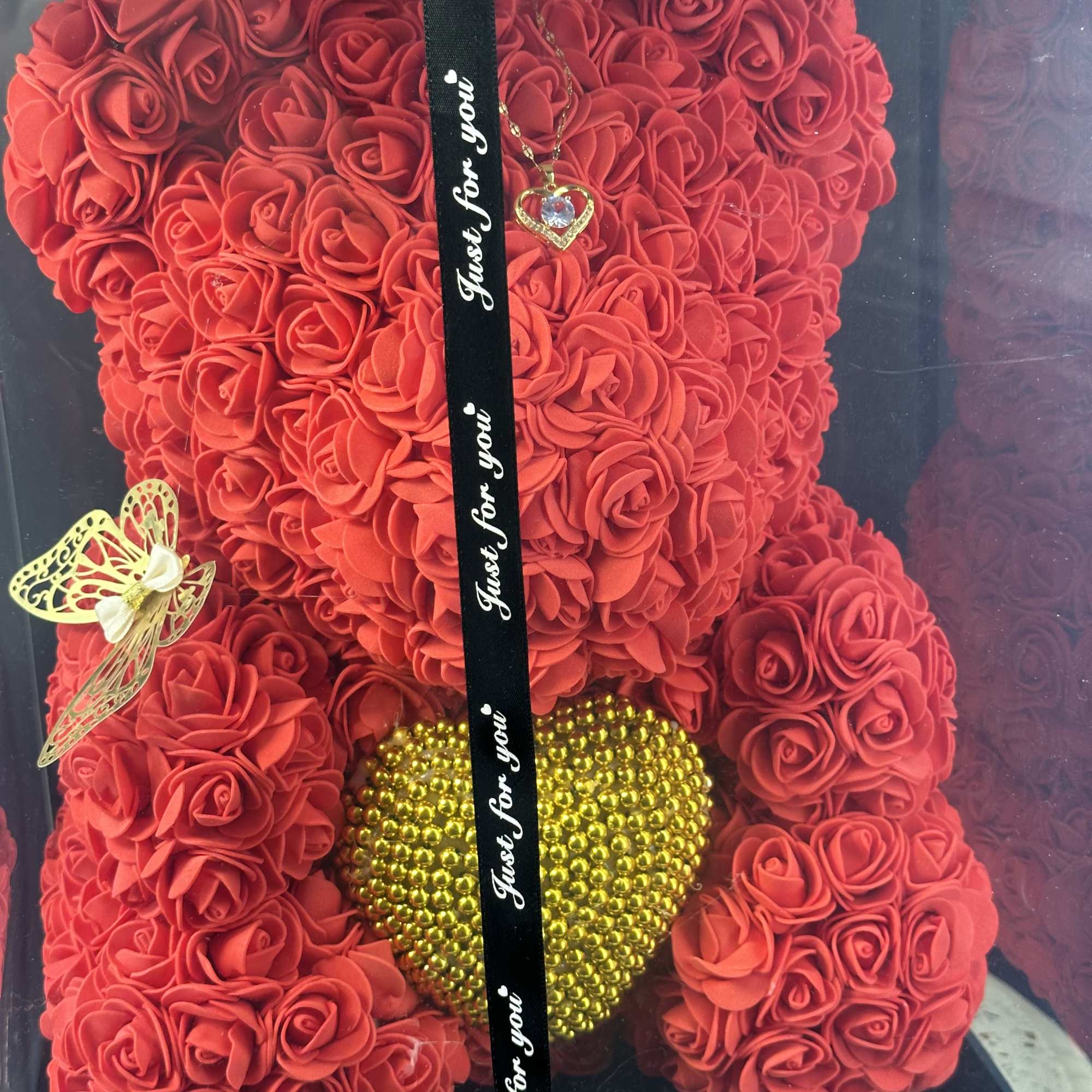 Red rose teddy bear with a gold heart and black ribbon