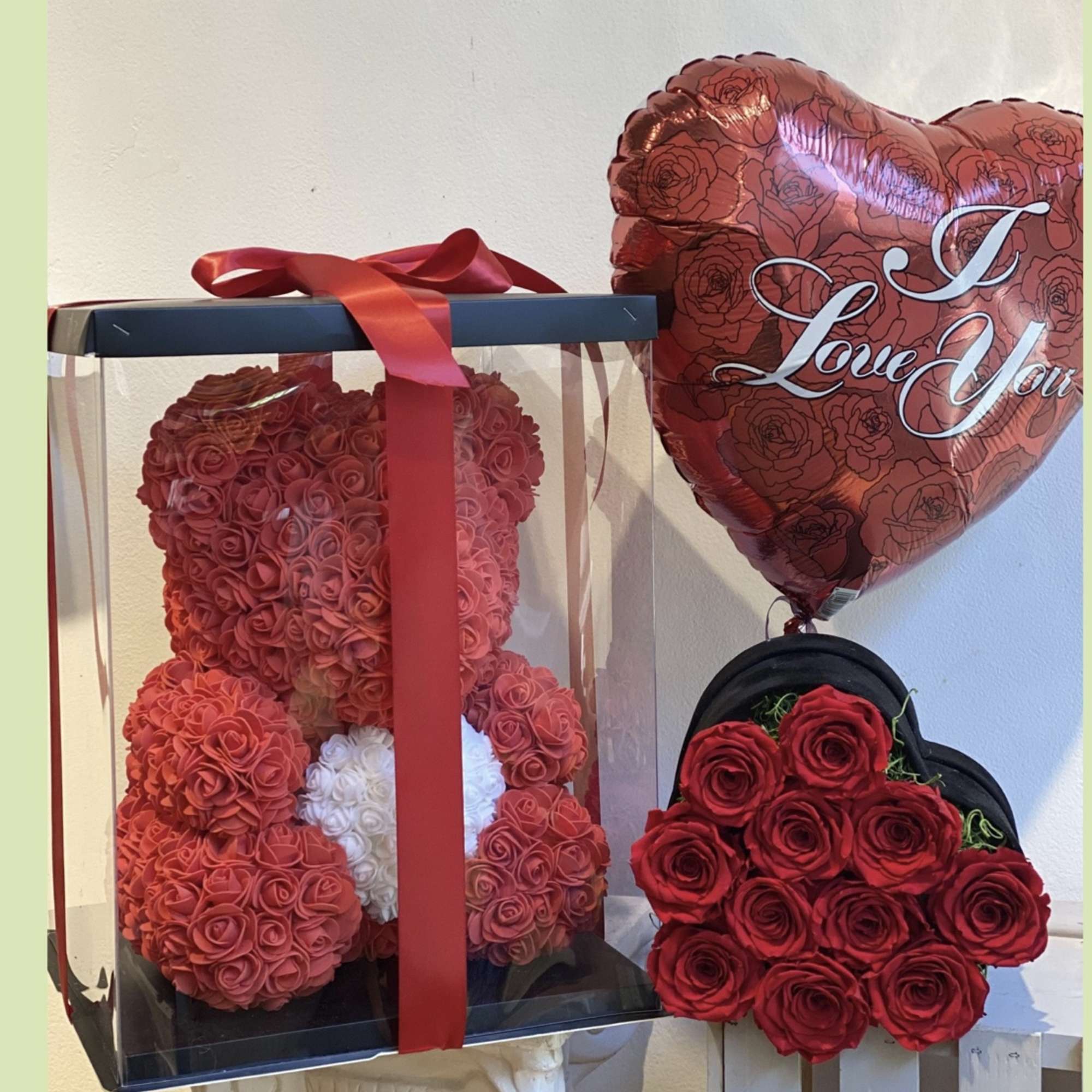 Rose teddy bear in a clear gift box with a red heart balloon and rose bouquet