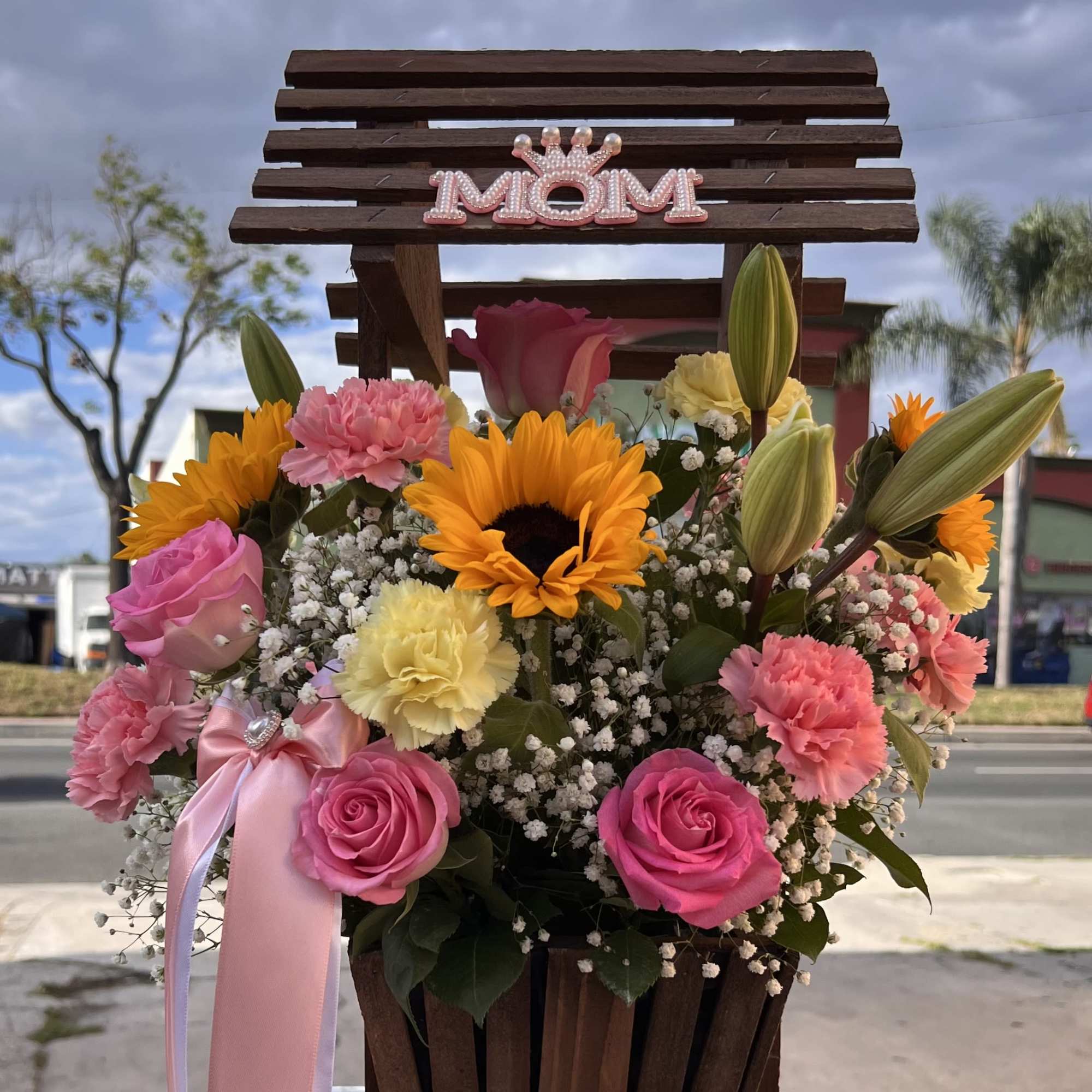 A bright and cheerful mix of sunflowers, roses, and delicate blooms, made