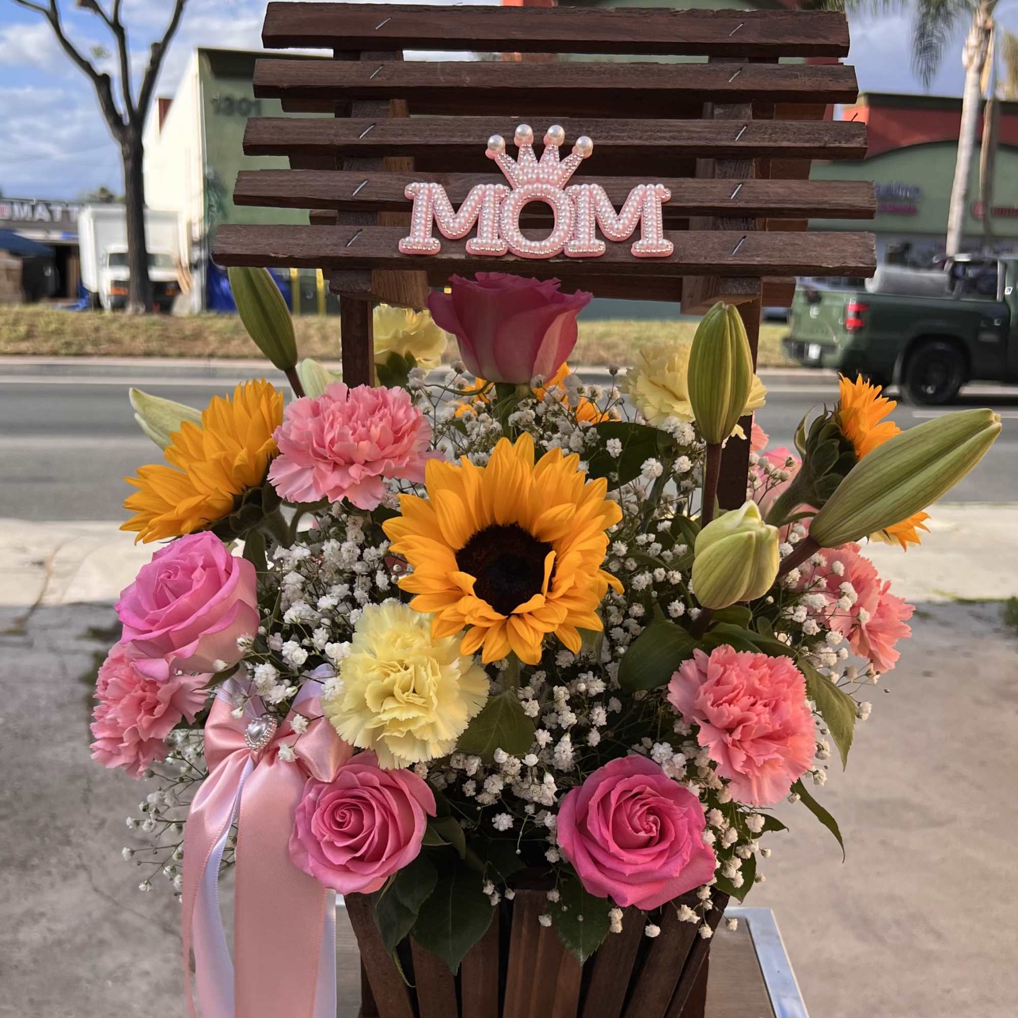 A bright and cheerful mix of sunflowers, roses, and delicate blooms, made