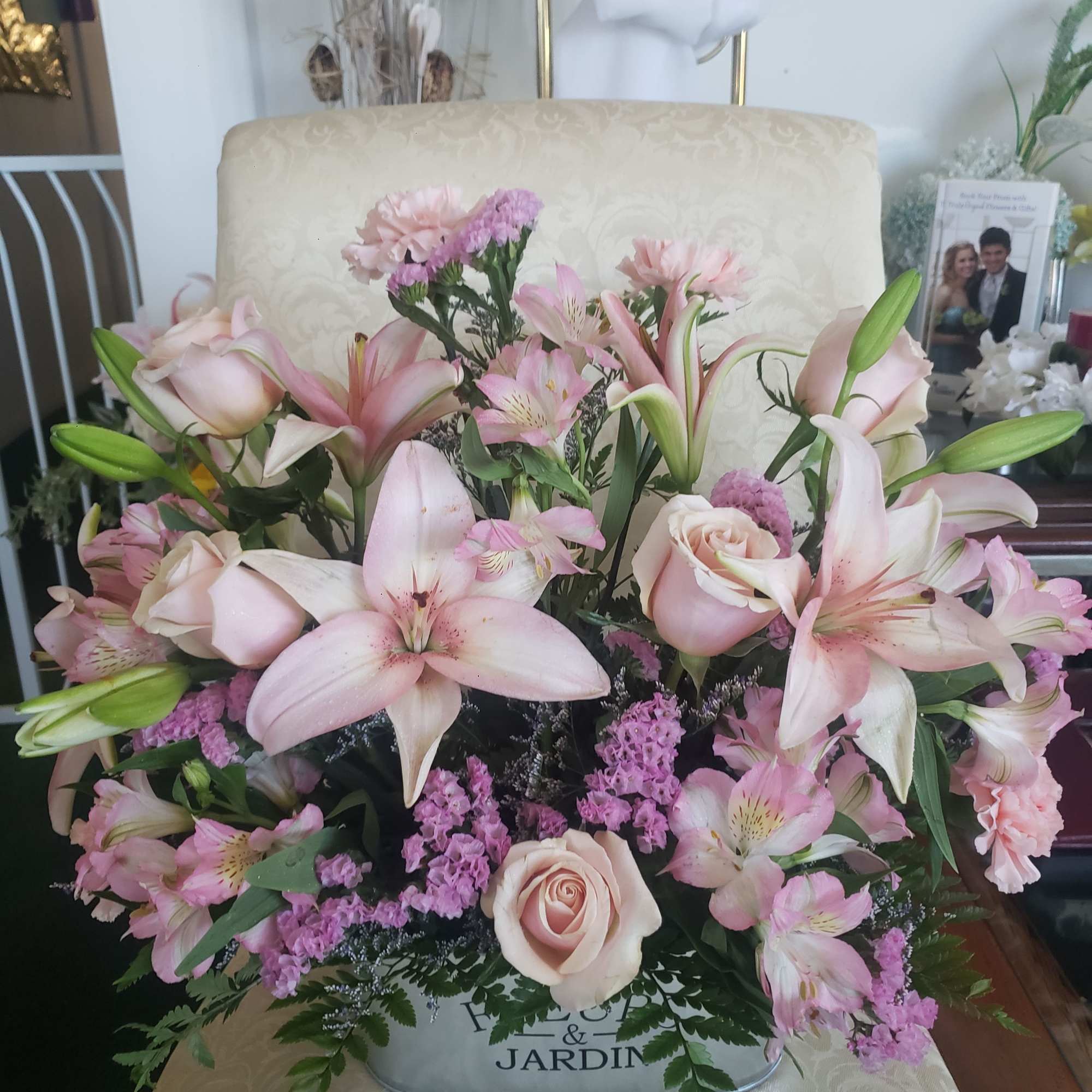 Pale pink lilies and soft blush roses form the heart of this
