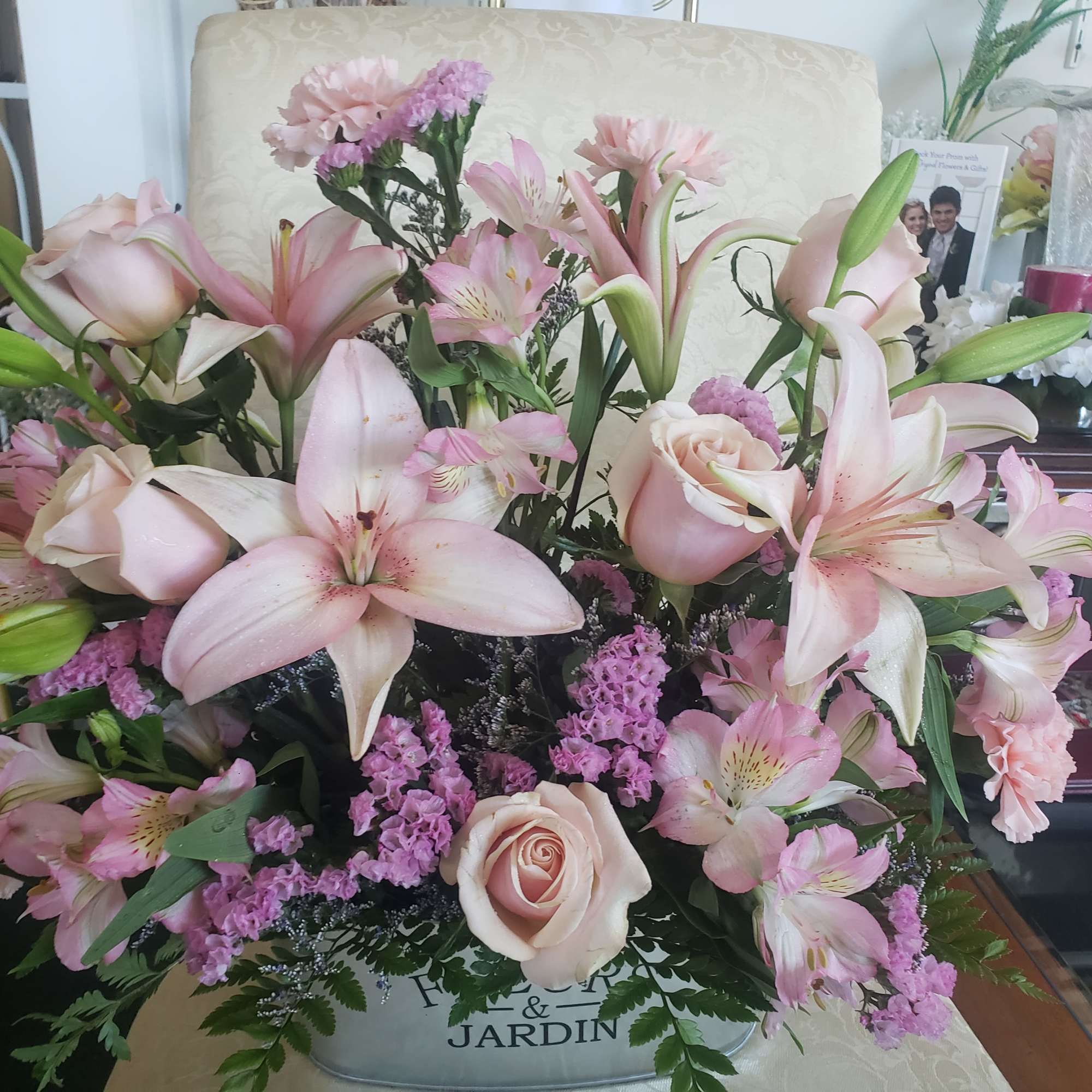 Pale pink lilies and soft blush roses form the heart of this