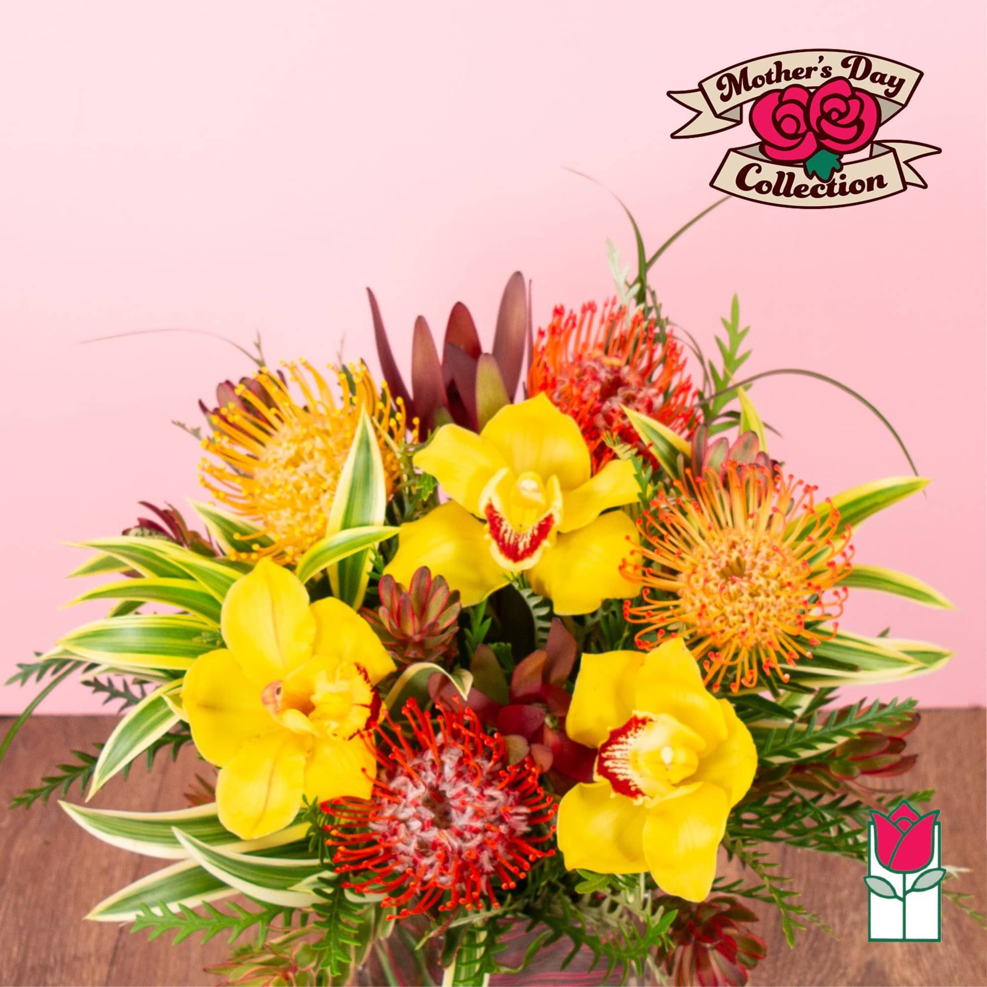 Bright arrangement of yellow orchids and orange pincushion blooms in a clear vase.