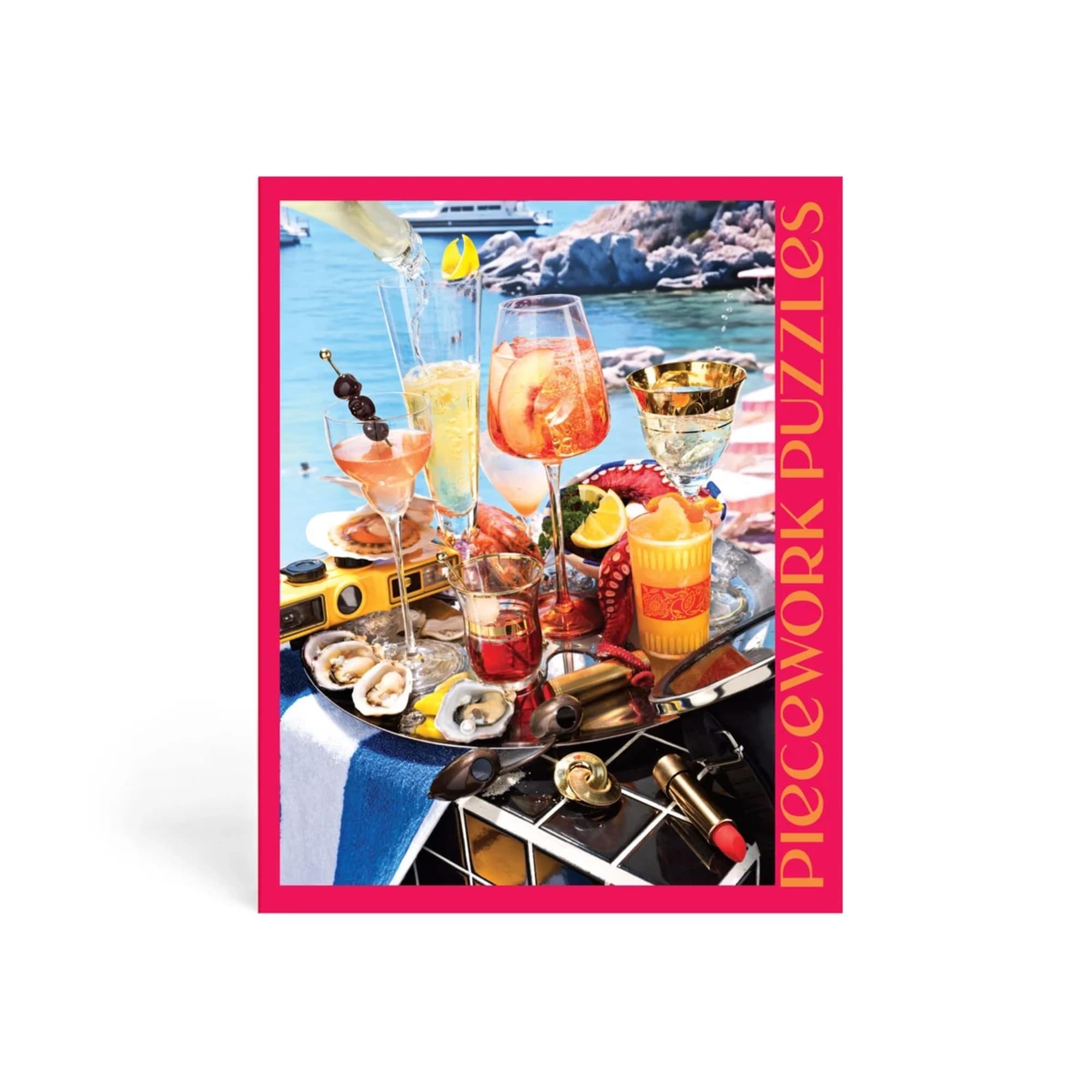 Colorful jigsaw puzzle box featuring a seaside table with cocktails and snacks
