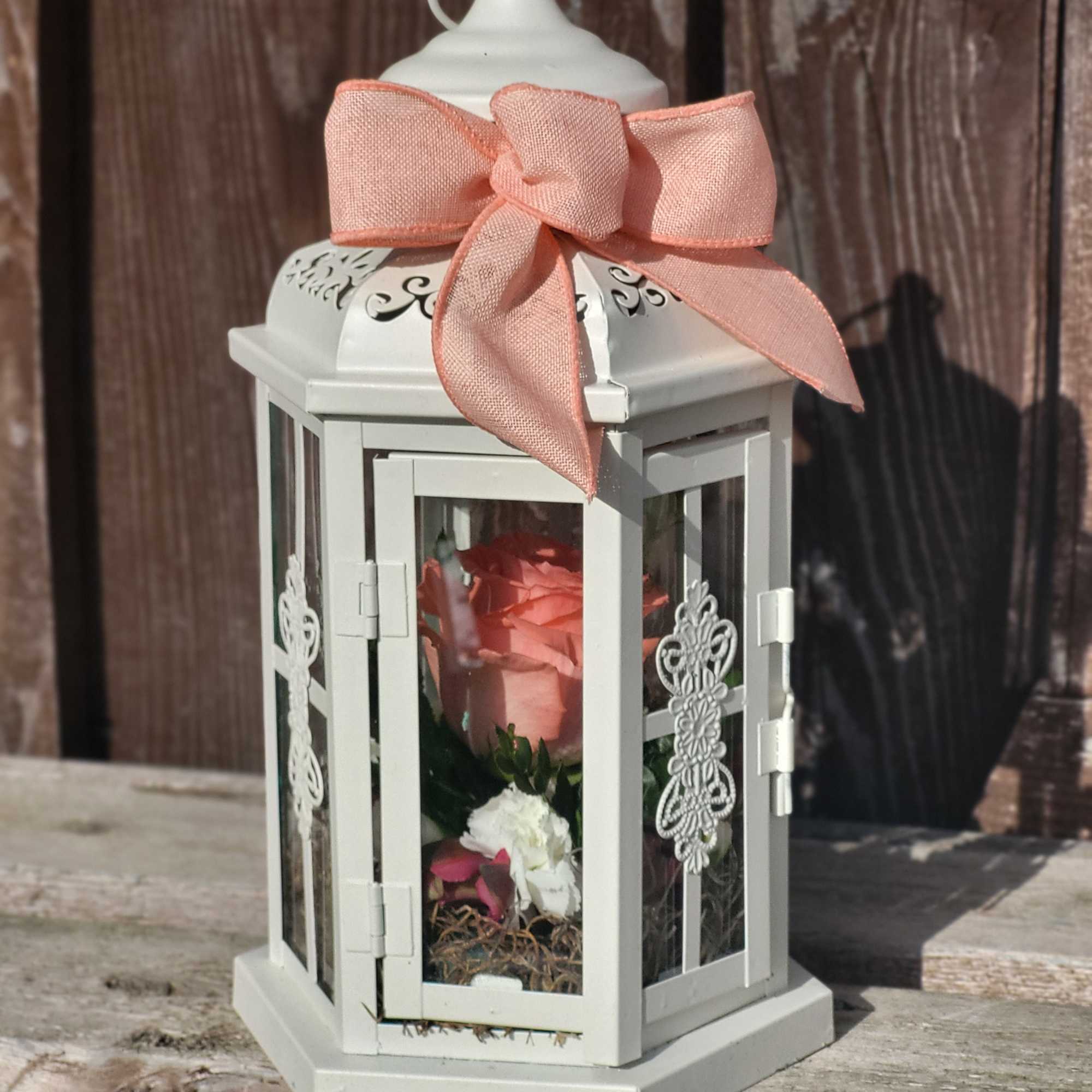 White lantern with a pink ribbon and a pink rose inside