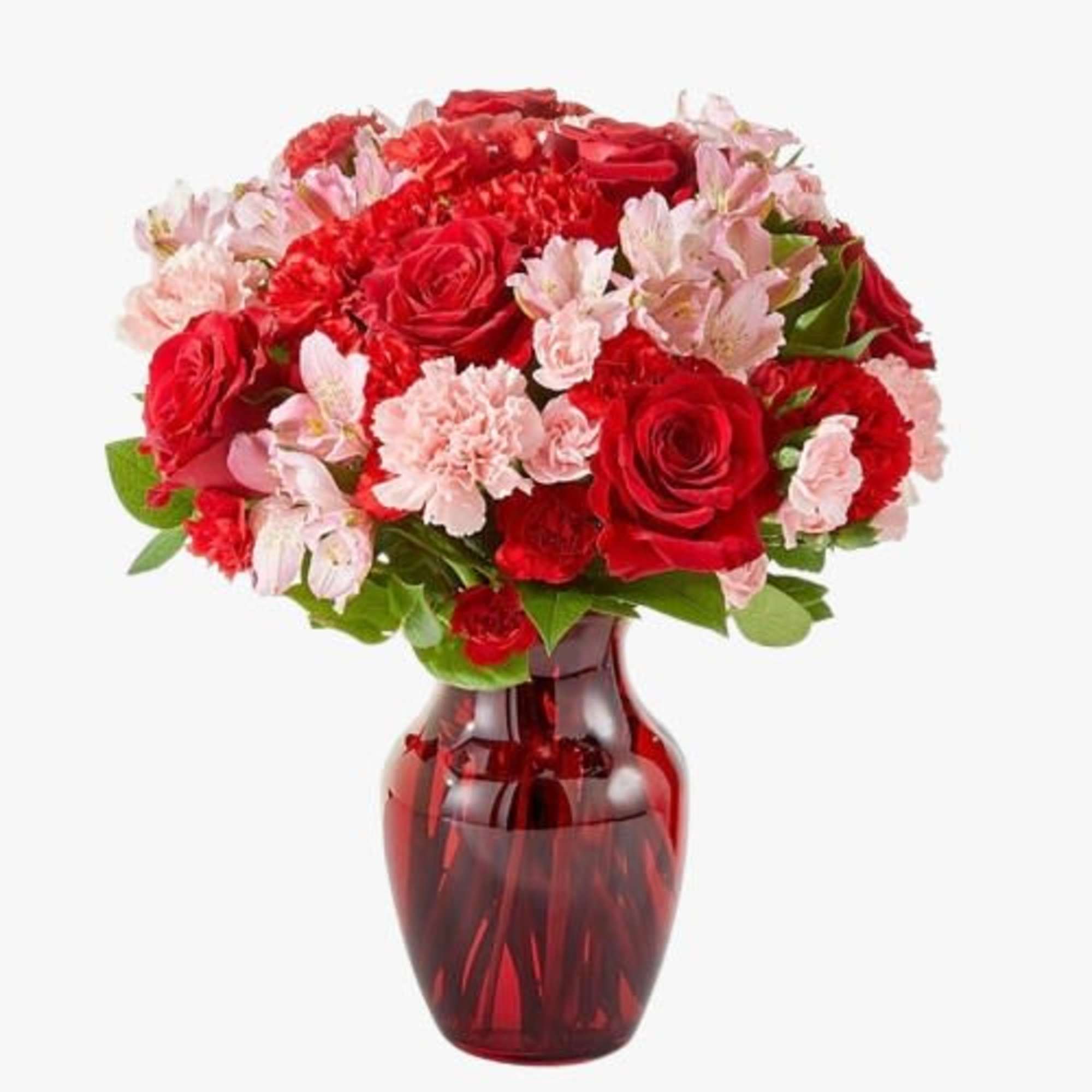 Red roses and pink carnations in a red glass vase