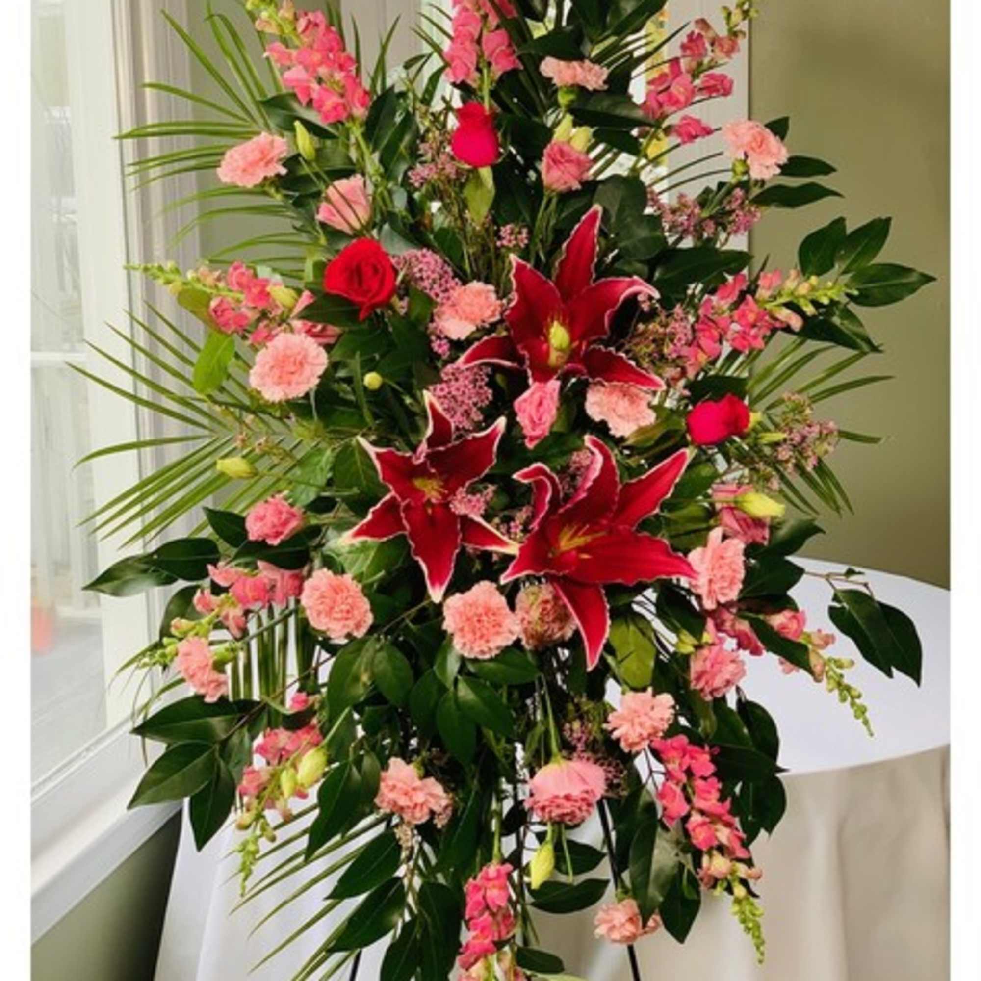 Tall floral spray with red lilies and pink carnations