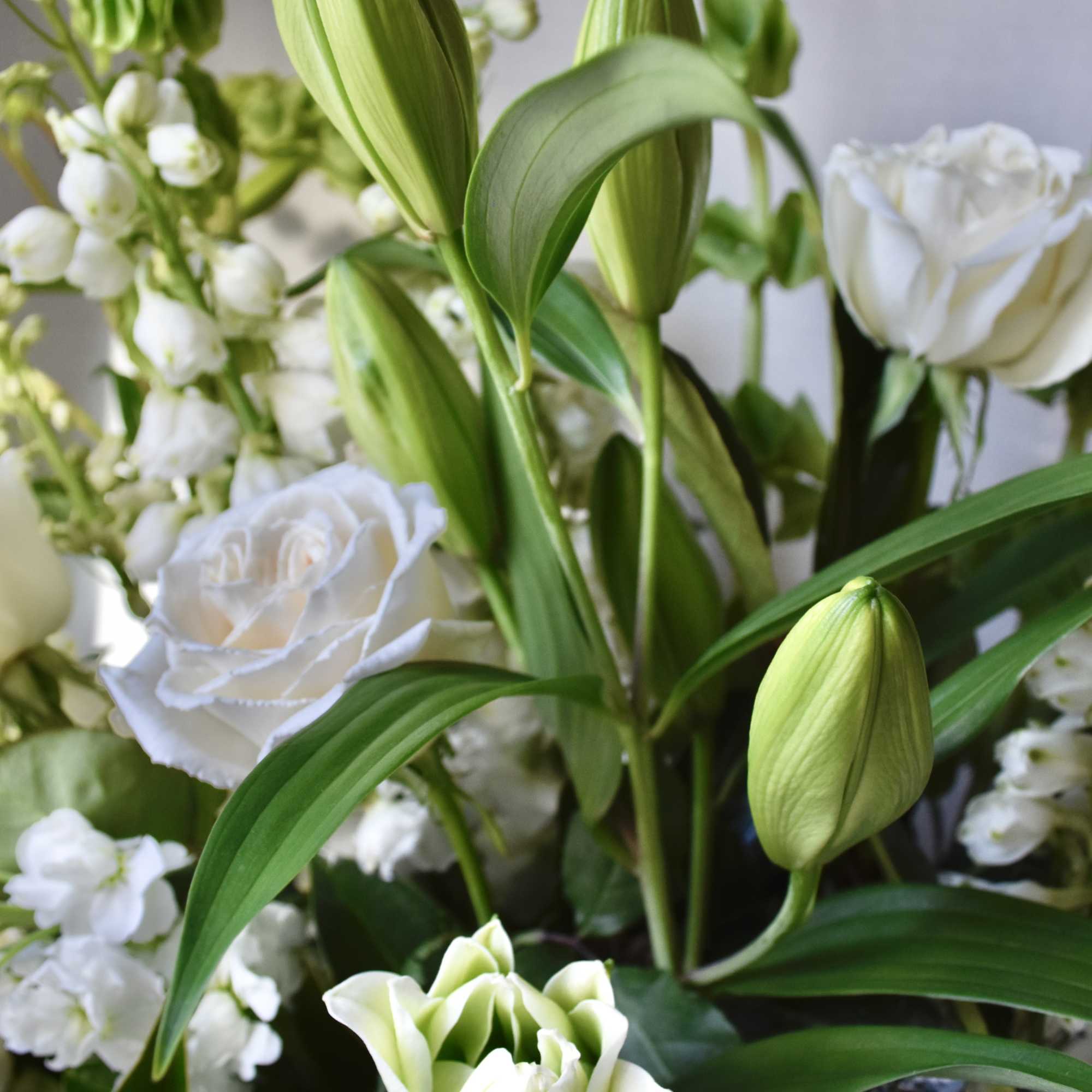 White lilies and roses with small white filler flowers