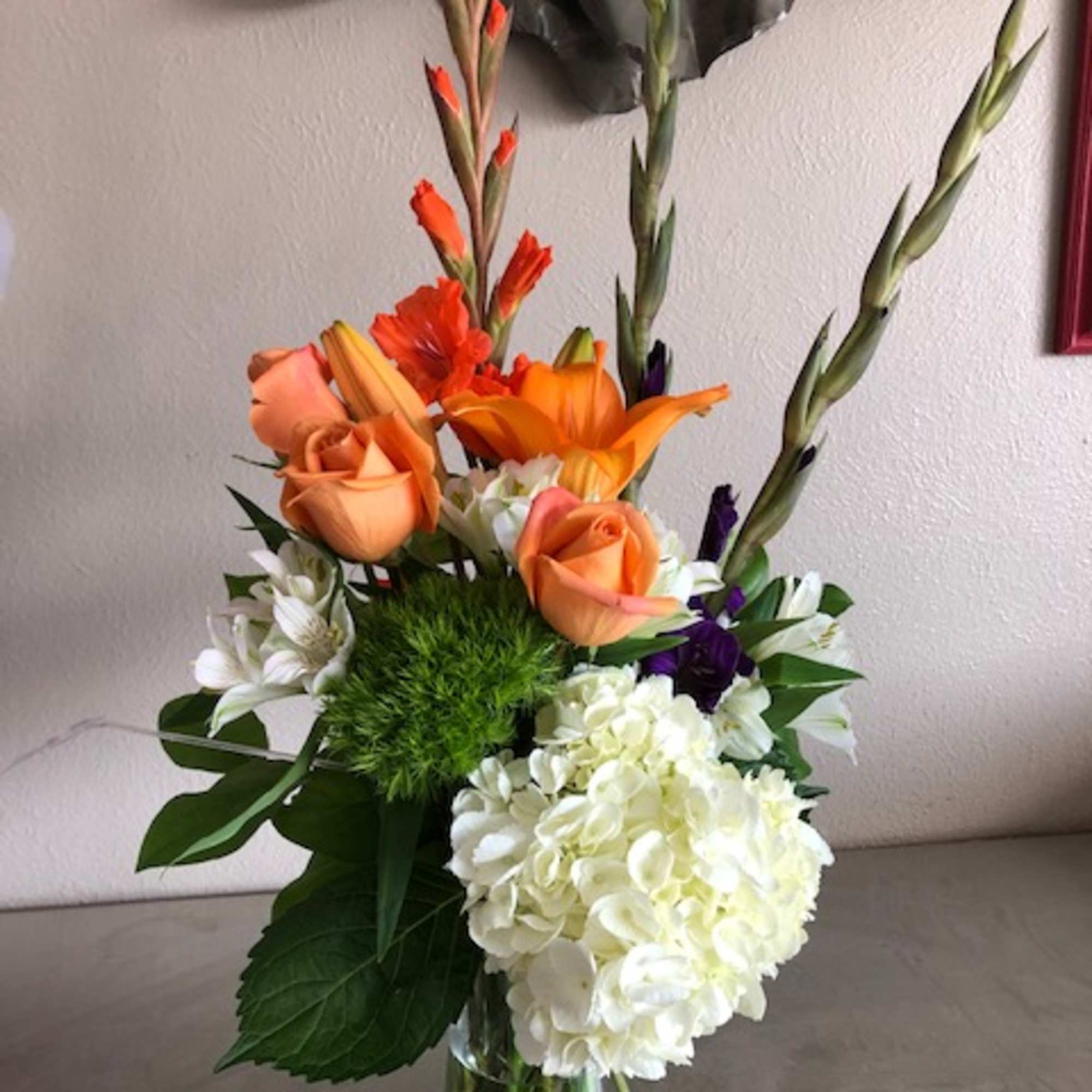 Orange roses and white hydrangea in a glass vase