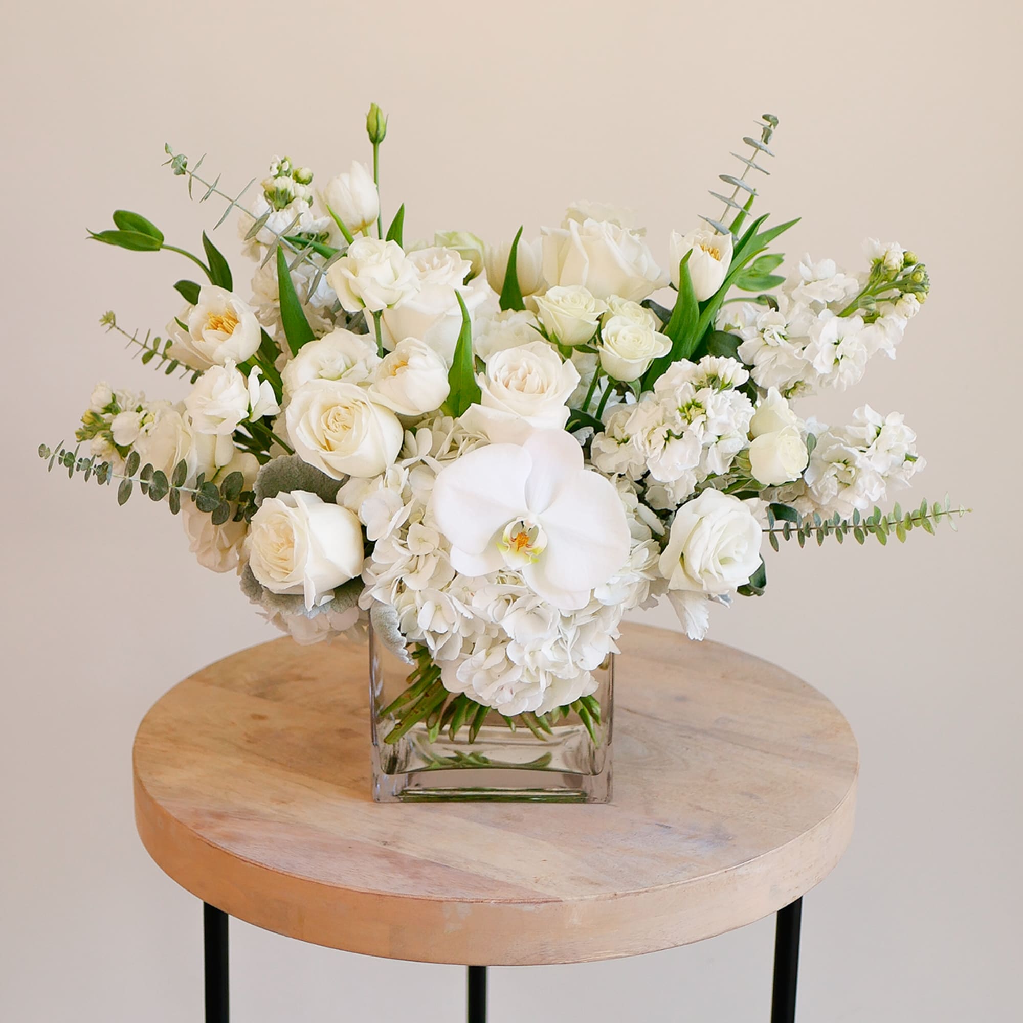 White floral arrangement in a clear square vase