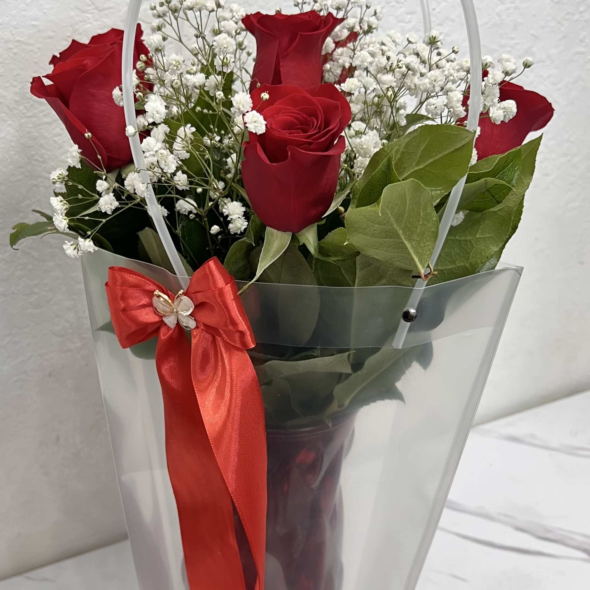 A charming arrangement of fresh red roses paired with delicate baby&rsquo;s breath