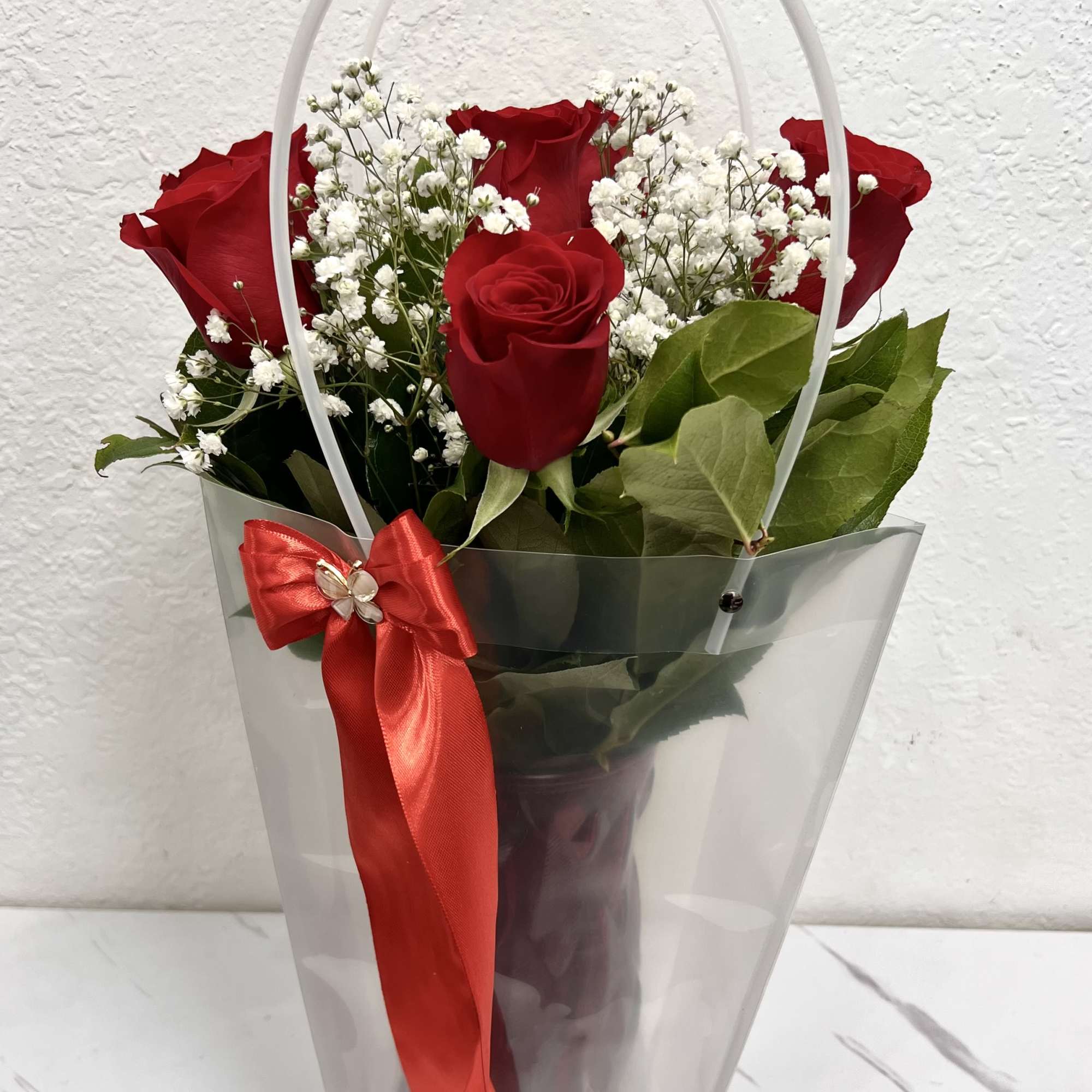 A charming arrangement of fresh red roses paired with delicate baby&rsquo;s breath