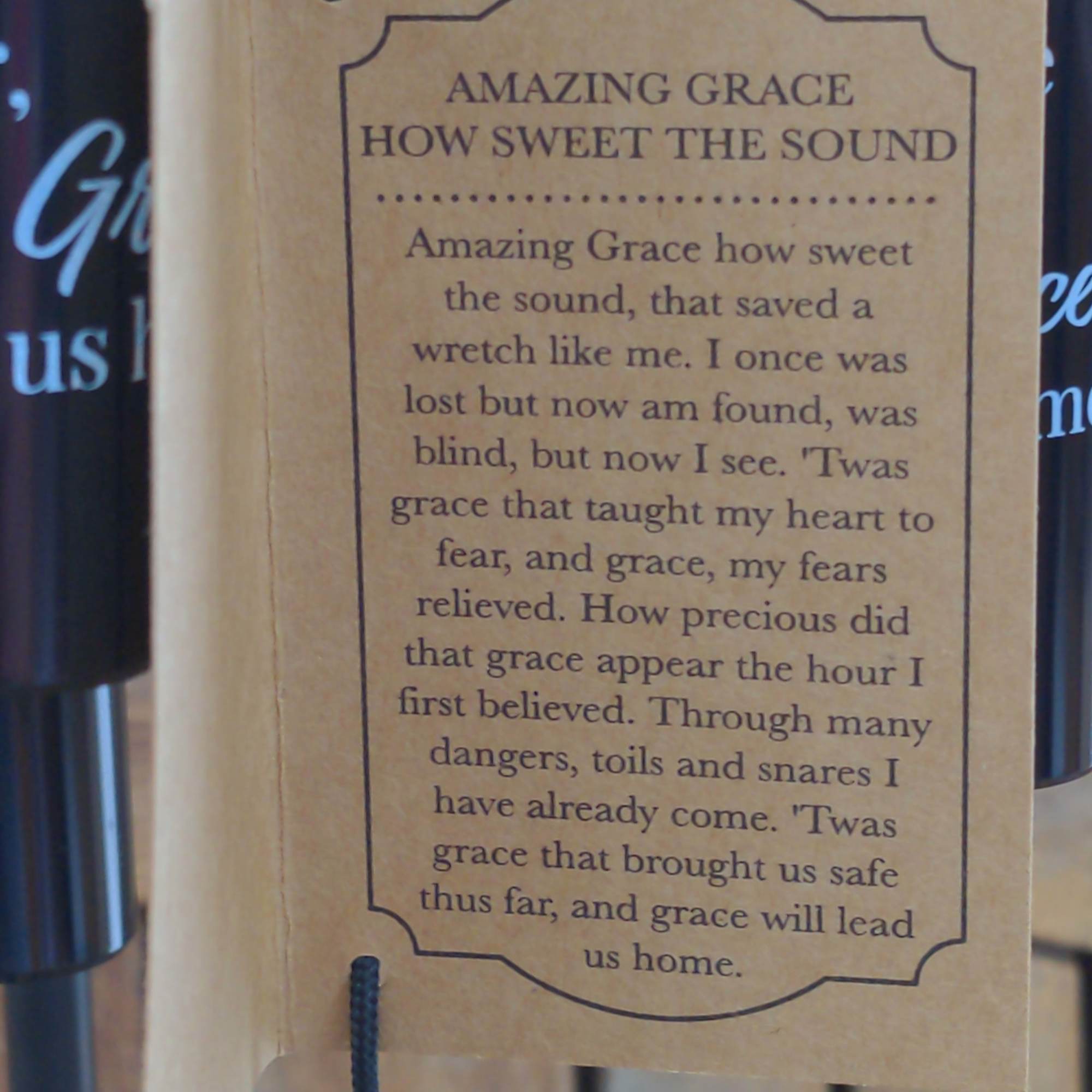 Brown hanging tag with the text "Amazing Grace" and a hymn verse