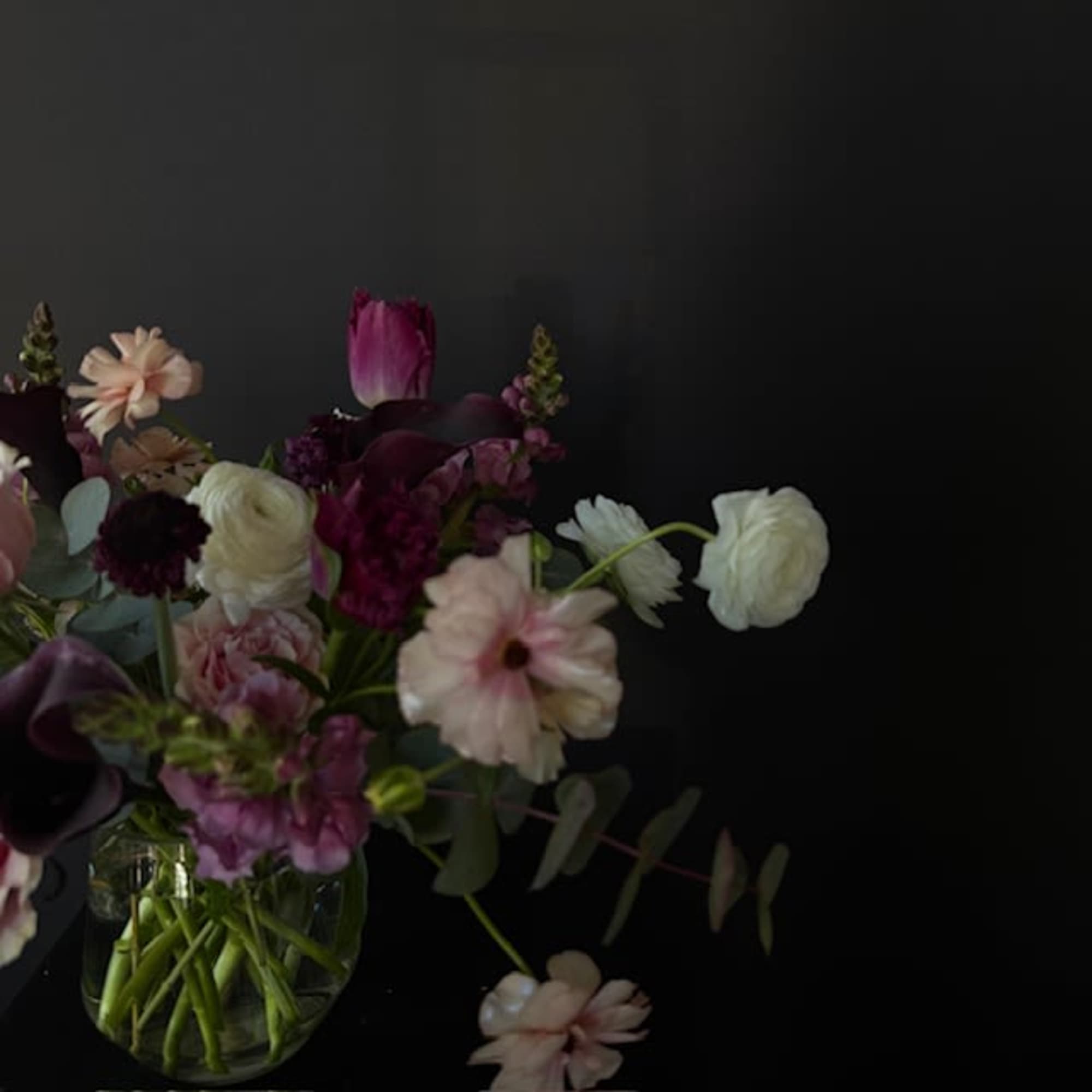 Mixed bouquet of pink, white, and purple flowers in a glass vase