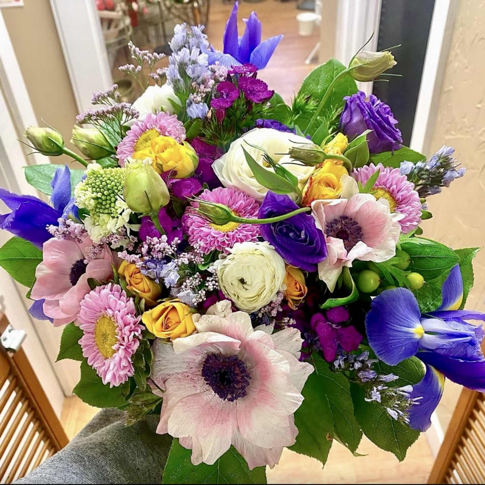 Mixed bouquet with pink anemones, purple irises, and yellow roses