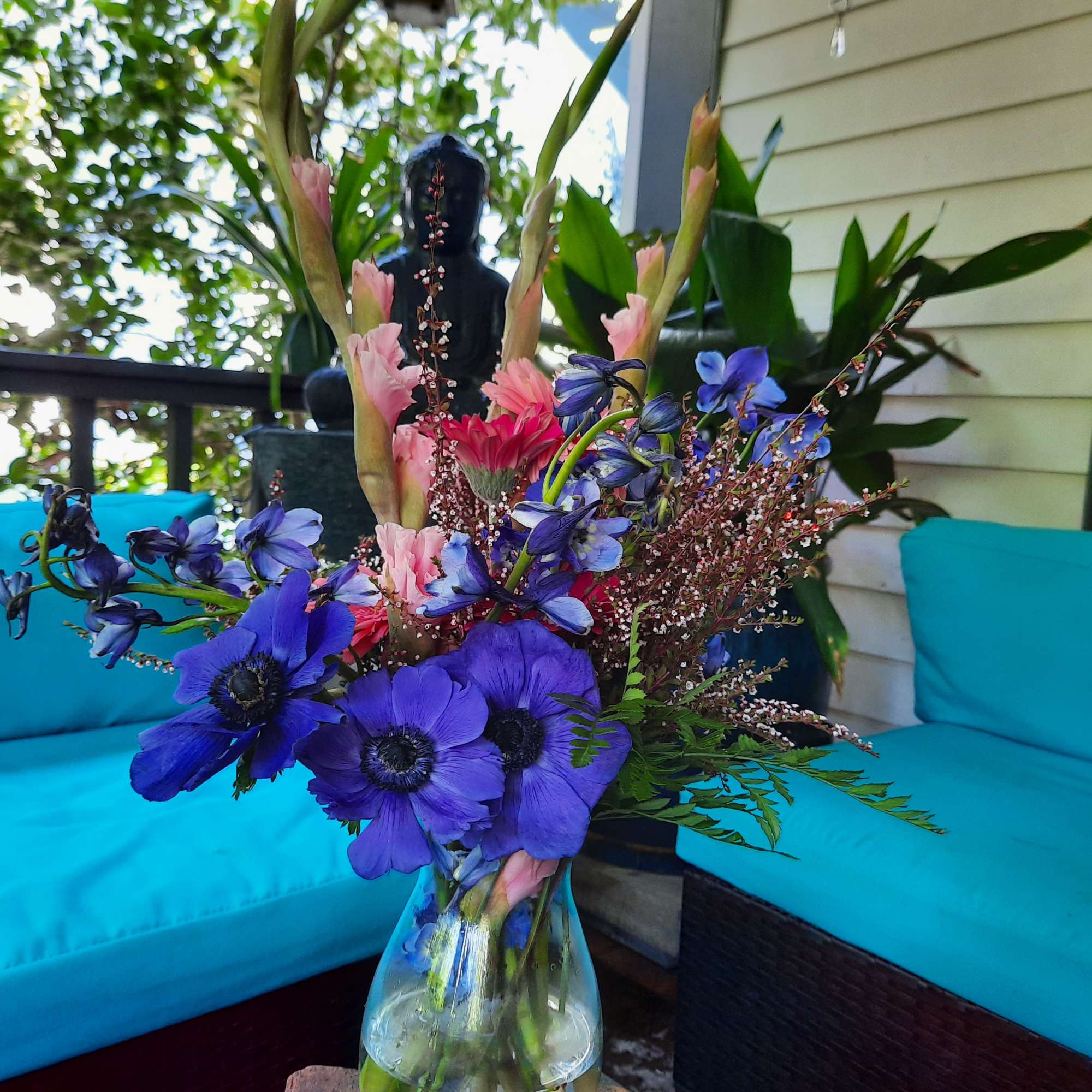 Blue and pink flower arrangement in a clear glass vase