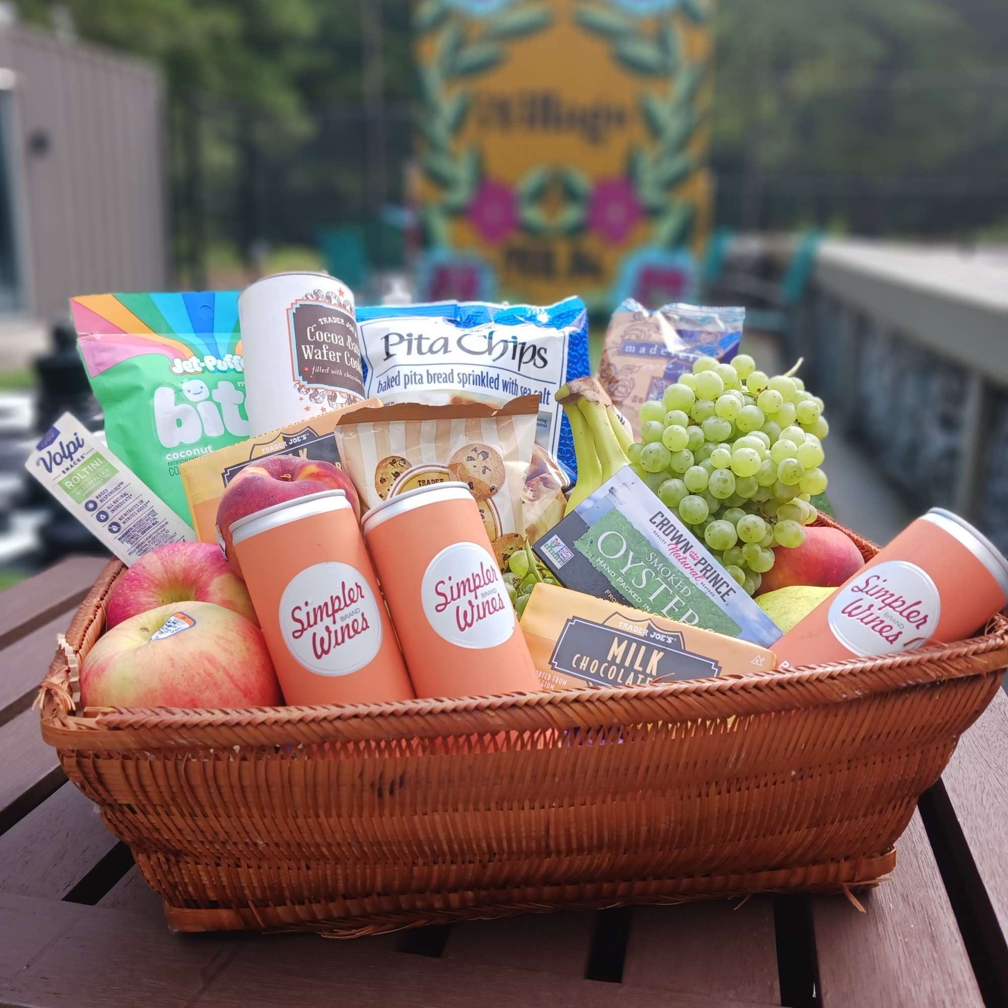 Gift basket with fruit, snacks, and canned wine