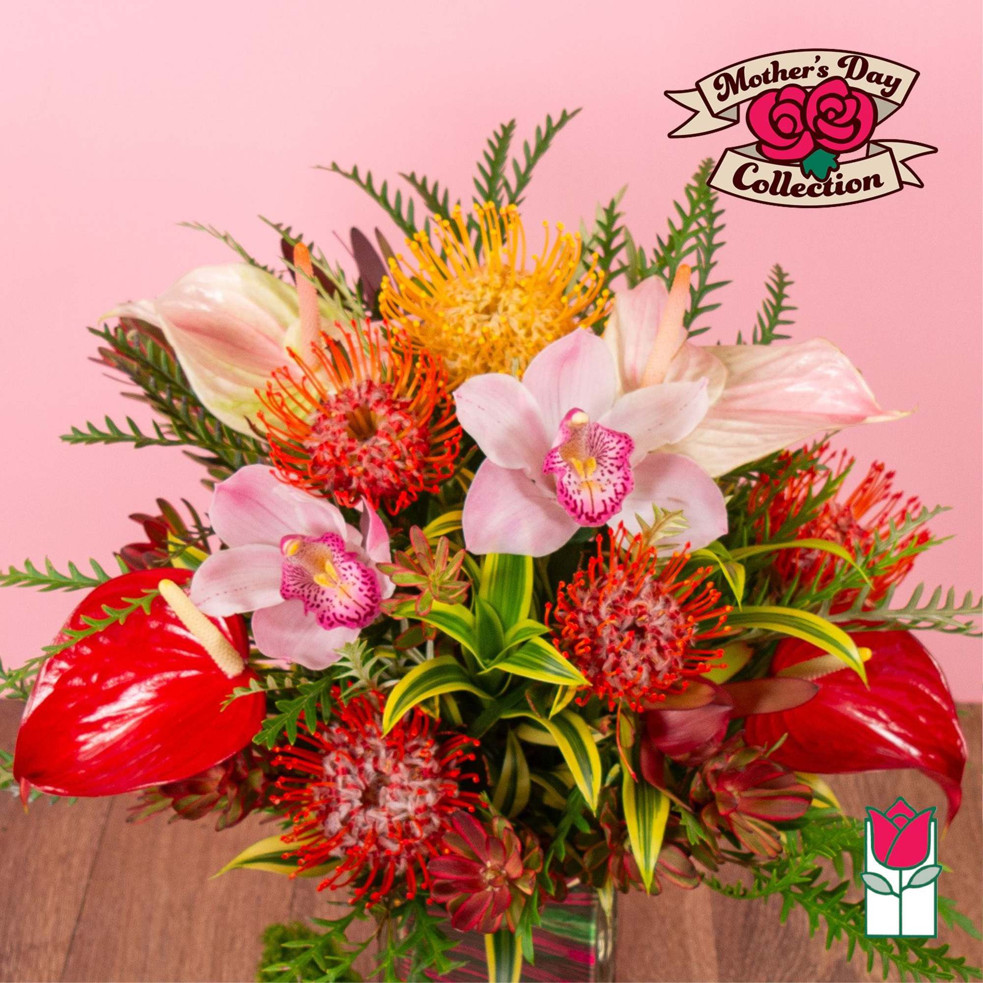 Tropical arrangement with pink orchids, red blooms, and yellow pincushion flowers in a glass vase