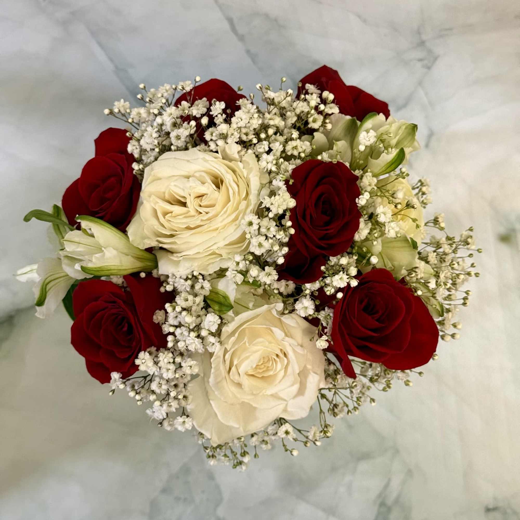 Deep, velvety red roses paired with creamy white peruvian lilies and delicate